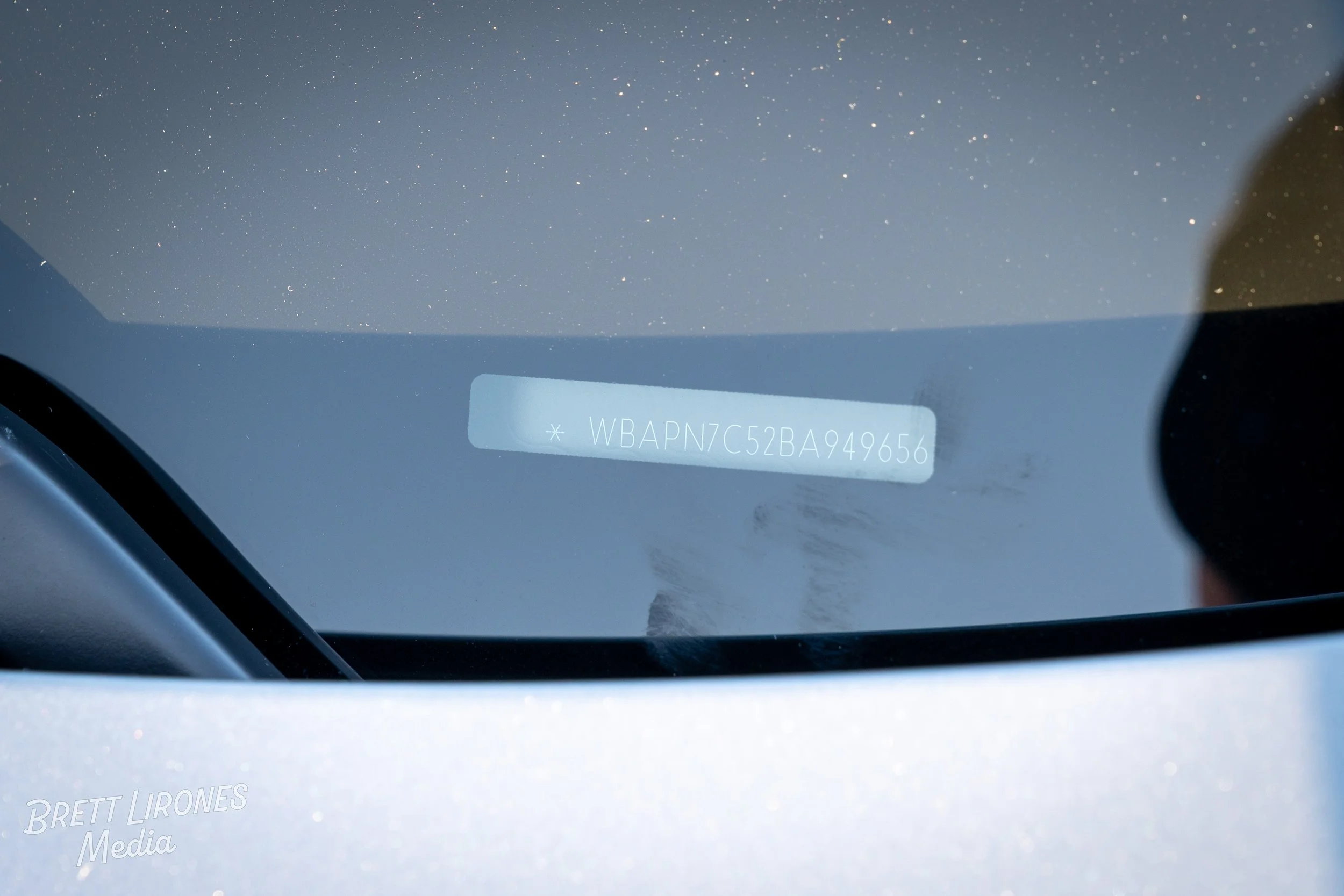 Close-up of a vehicle's windshield with a visible VIN number sticker on the inside.