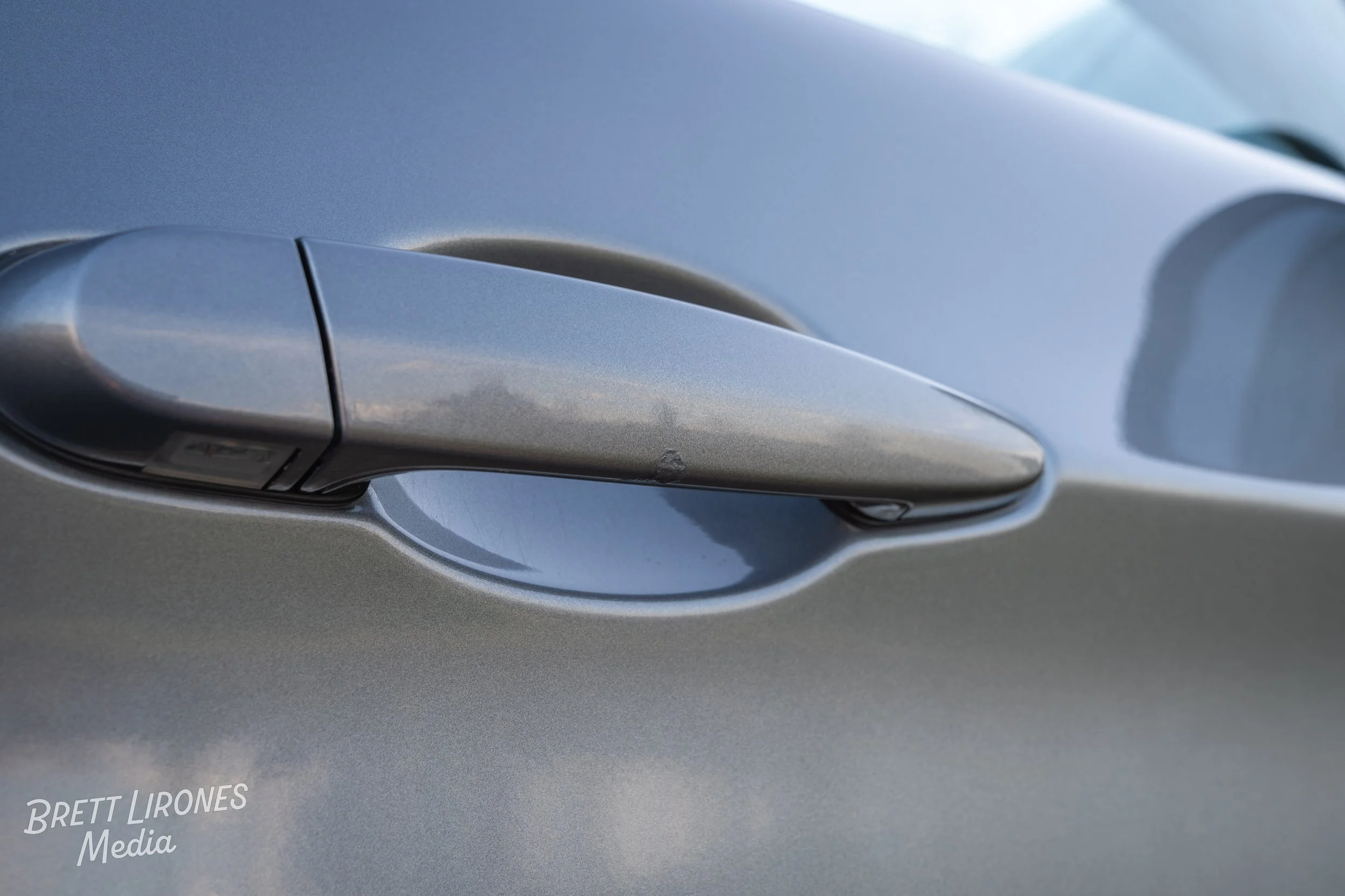 Close-up of a silver car door handle.