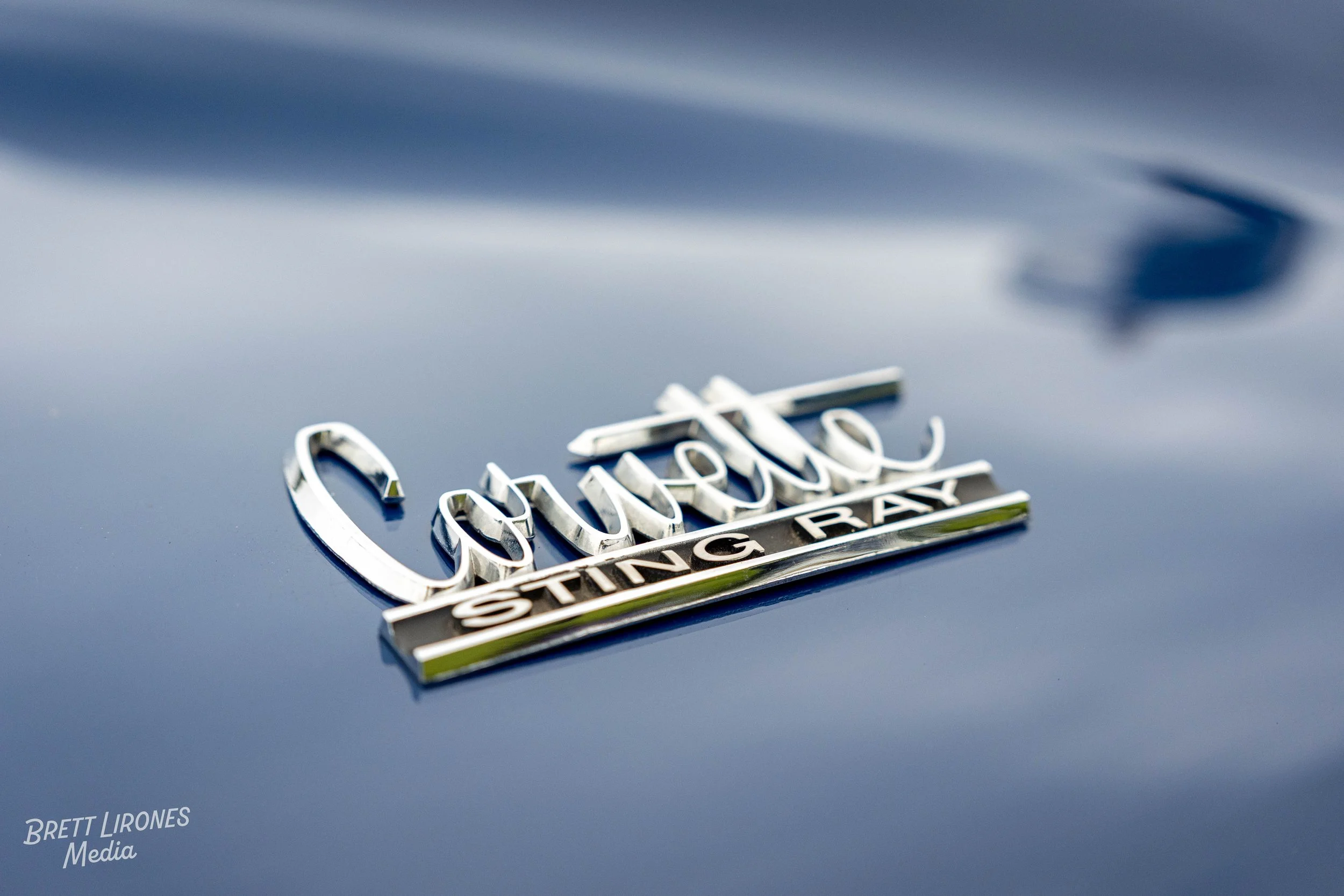 Close-up of a Chevrolet Camaro emblem with 'Sting Ray' badge on a car's hood.
