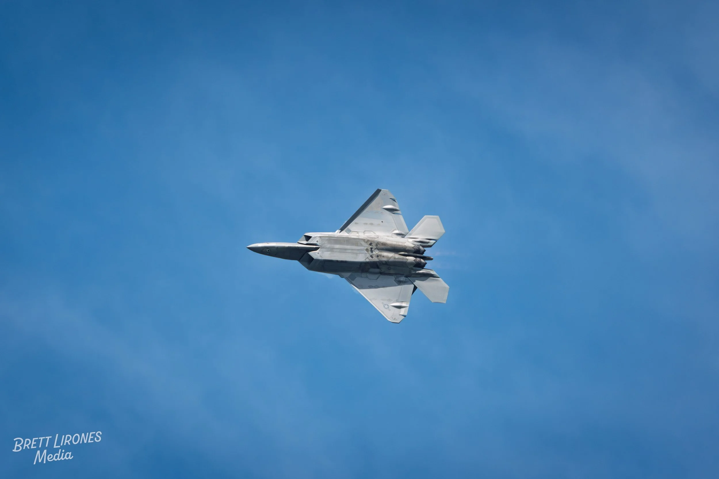 A fighter jet flying in a clear blue sky.