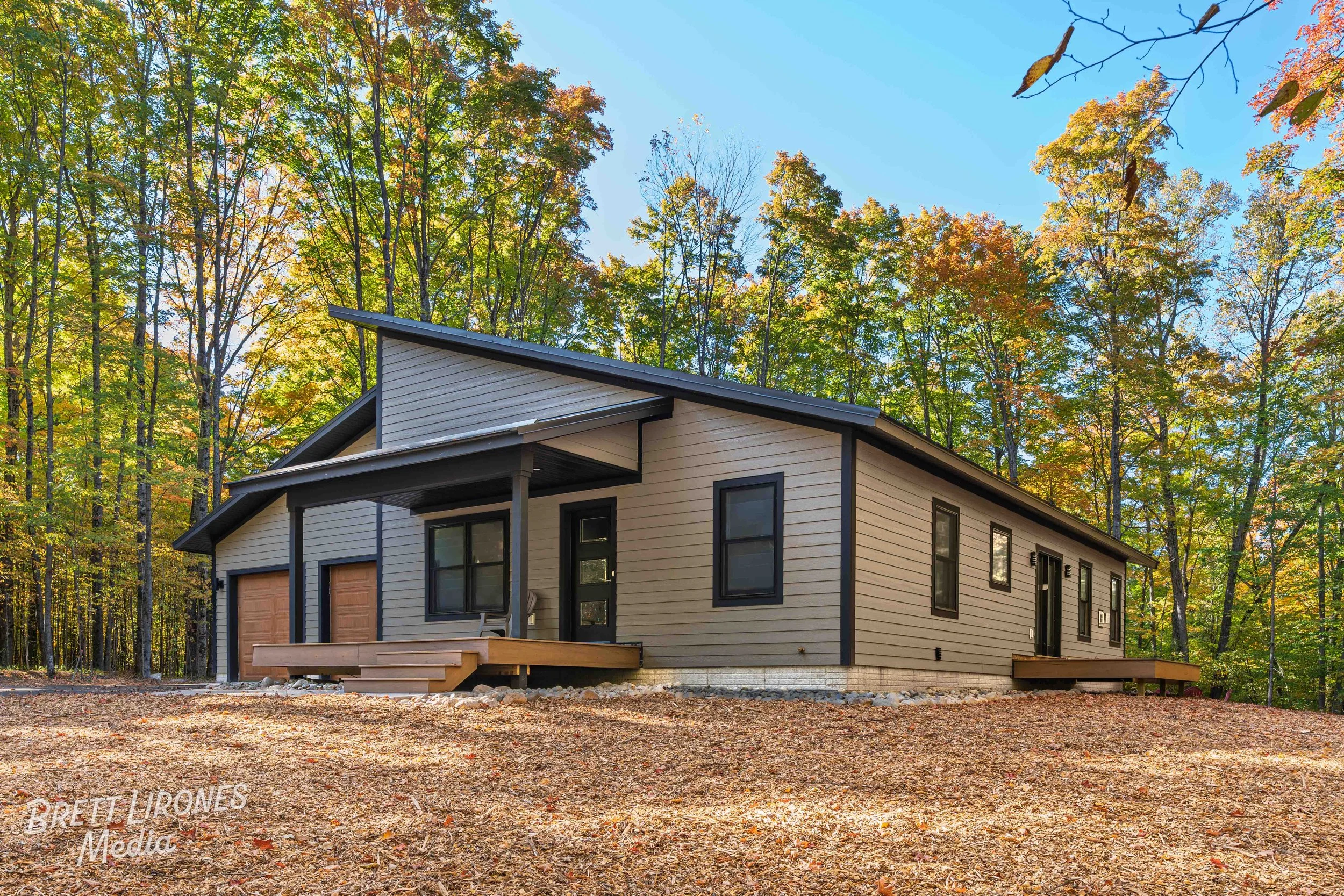 New modern house surrounded by trees with colorful autumn leaves.