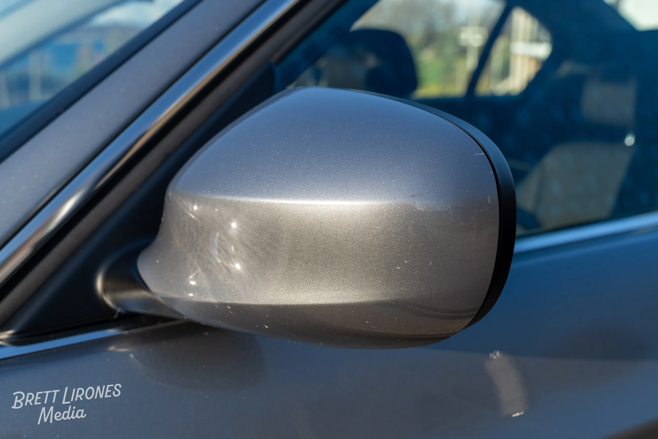Close-up of a silver car's side mirror.