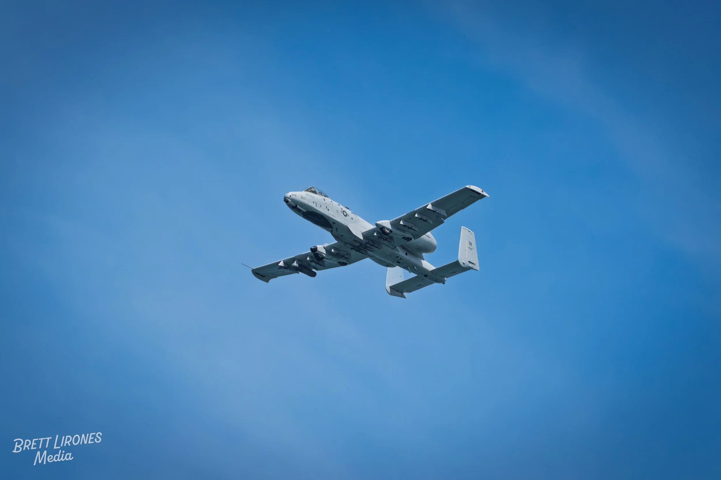 A military aircraft flying in clear blue sky.