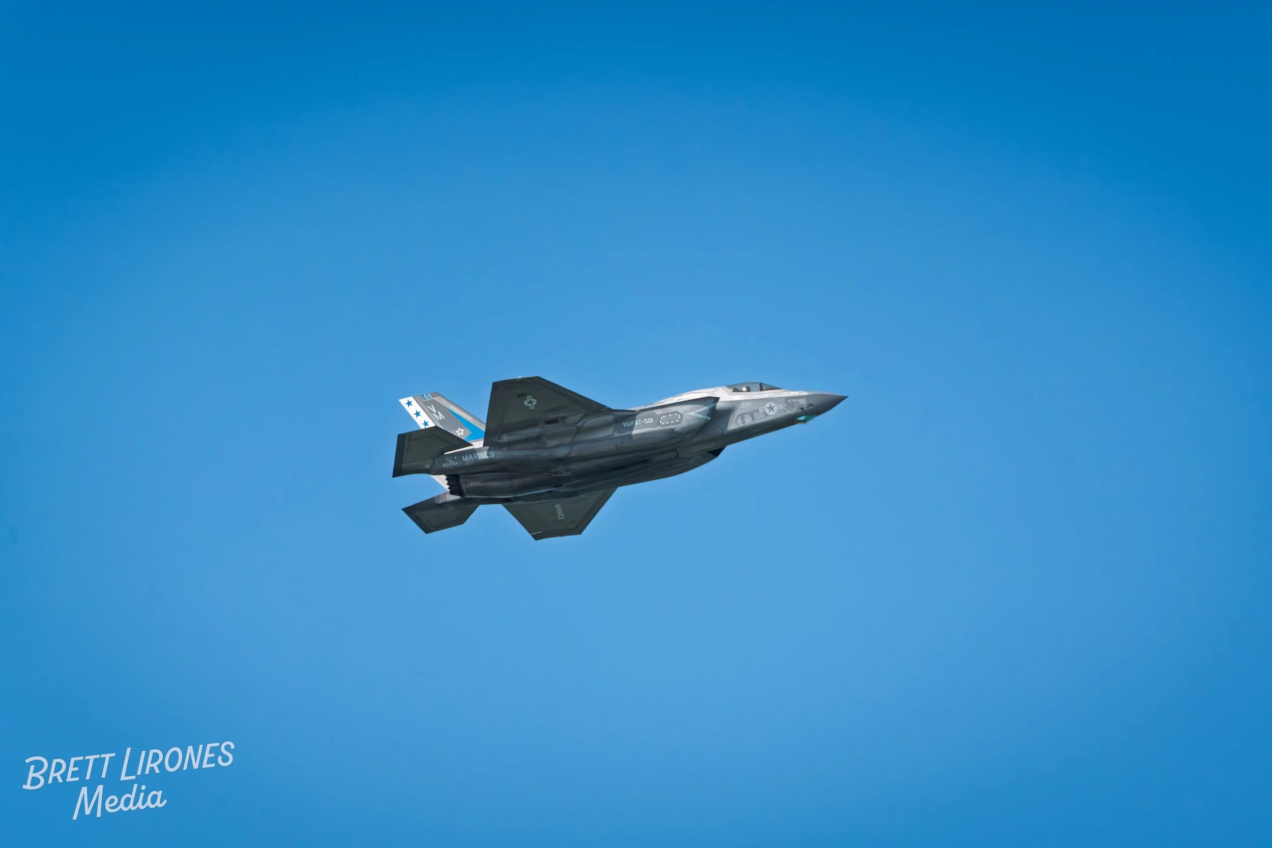 F-35 fighter jet flying in a clear blue sky.