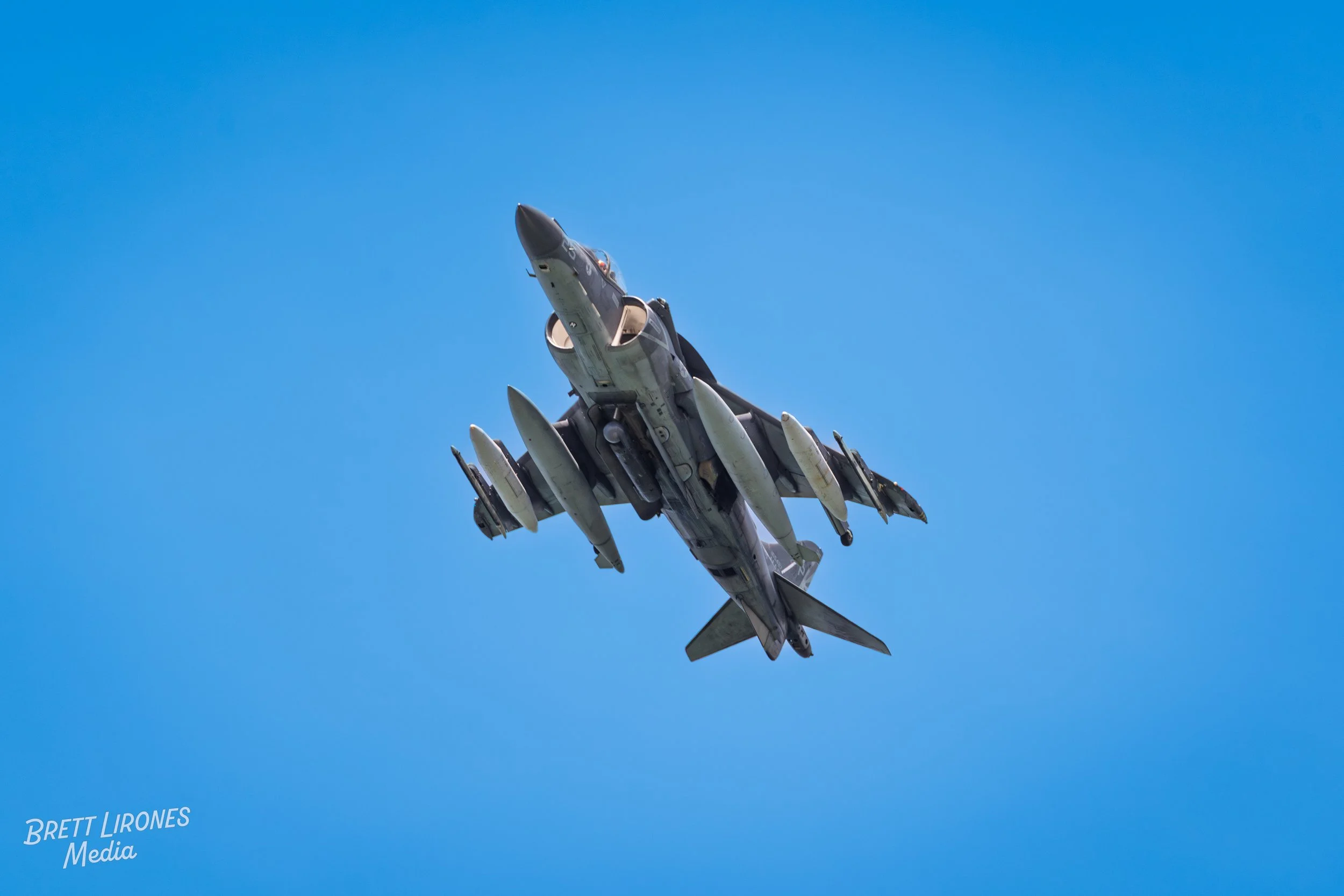 A fighter jet flying in a clear blue sky during the daytime.