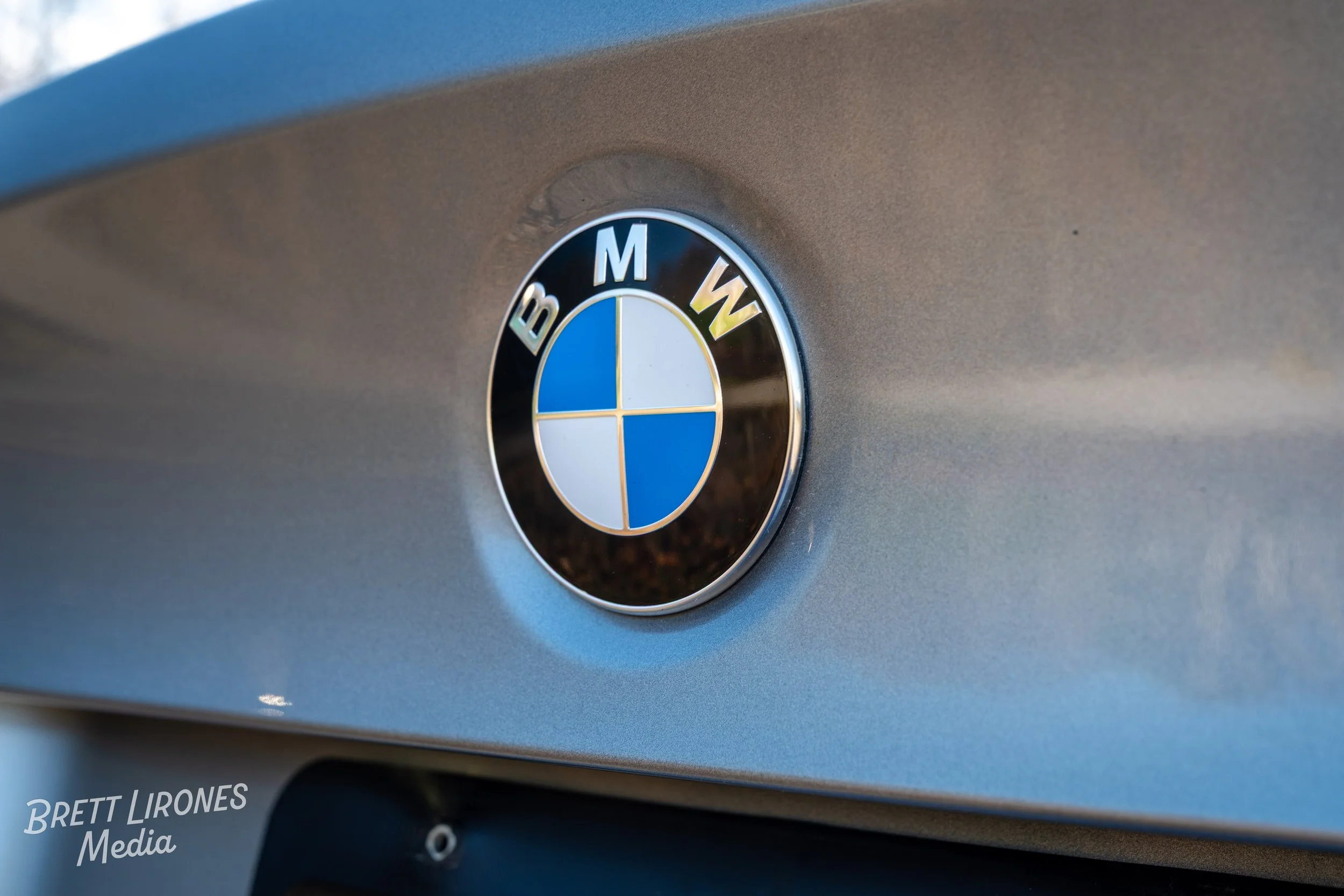 Close-up of BMW logo on the front of a silver car