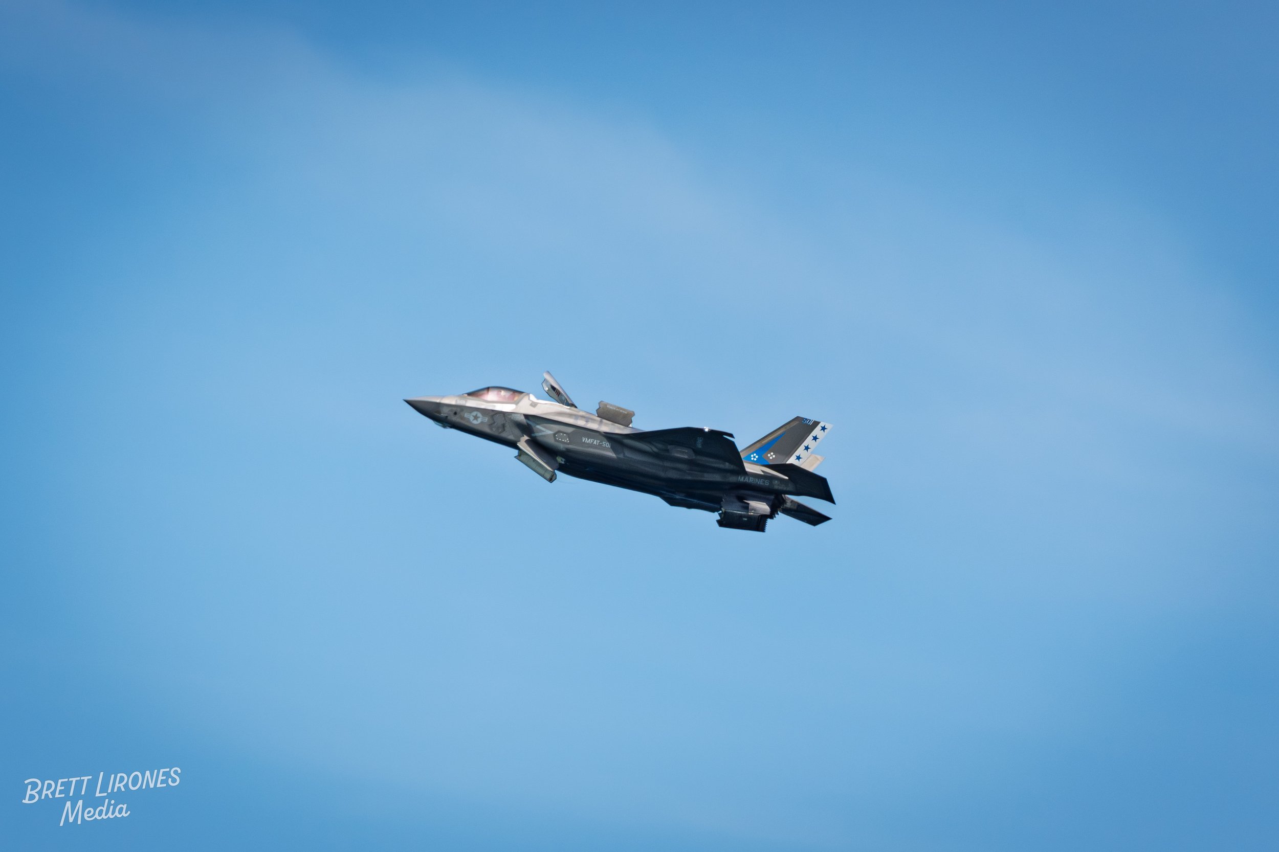 A modern fighter jet flying in a clear blue sky.