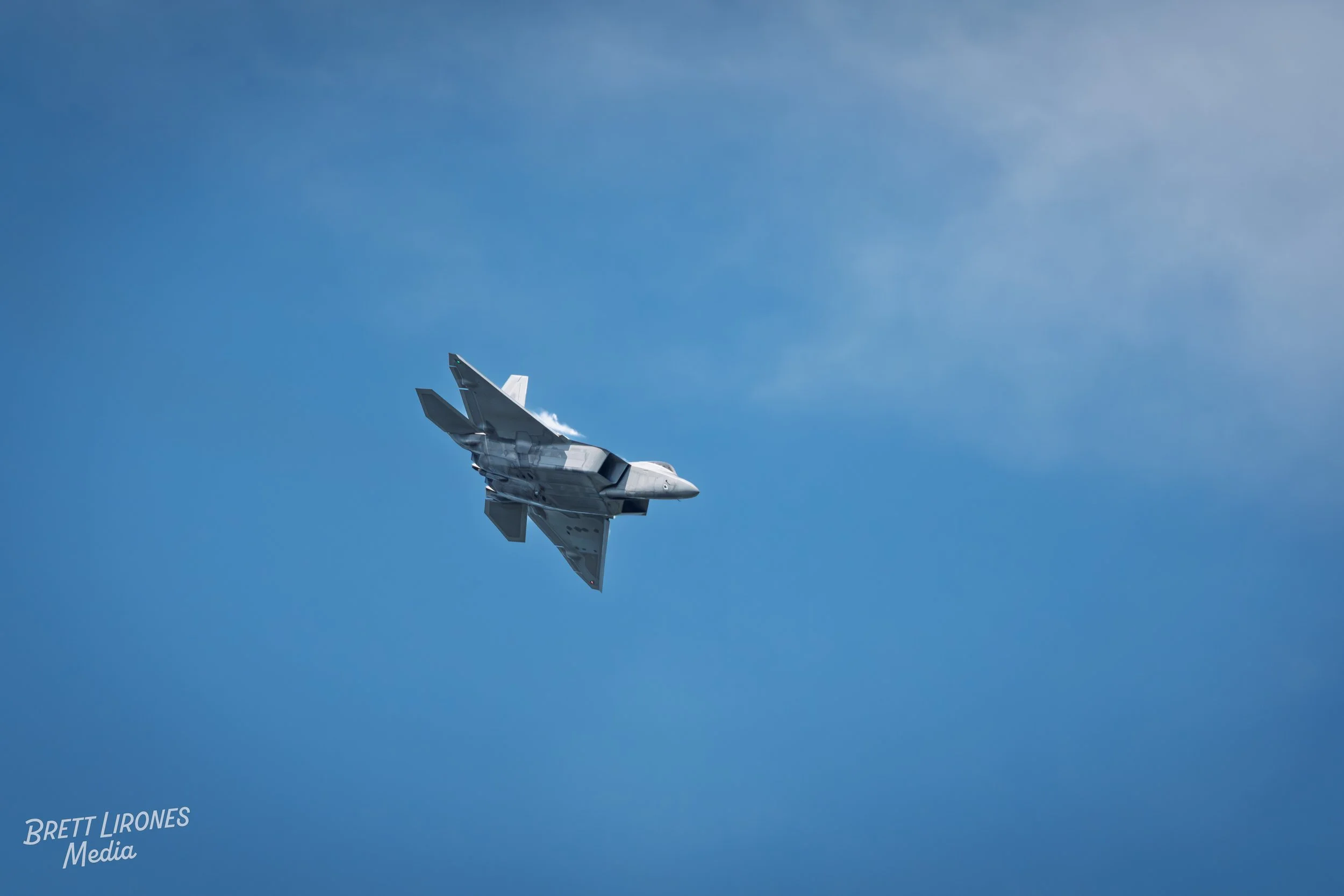 A fighter jet flying in a clear blue sky.
