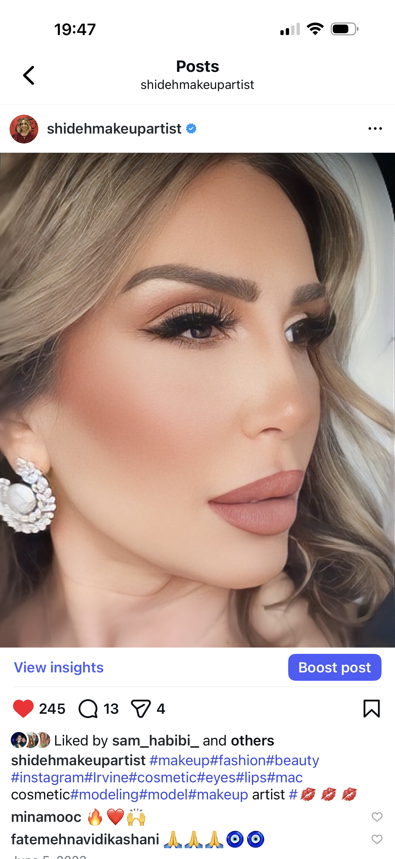 Close-up of a woman with makeup, earrings, and styled hair, looking to the side.