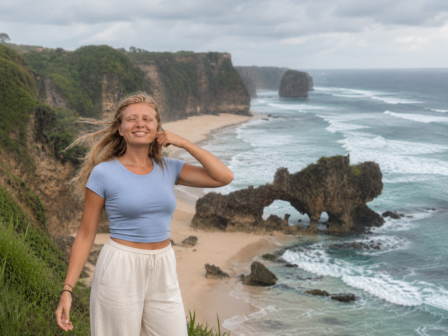 Ava Haag, founder of The Femme Explorer Studio, standing above a coastal beach in Sumba, Indonesia.