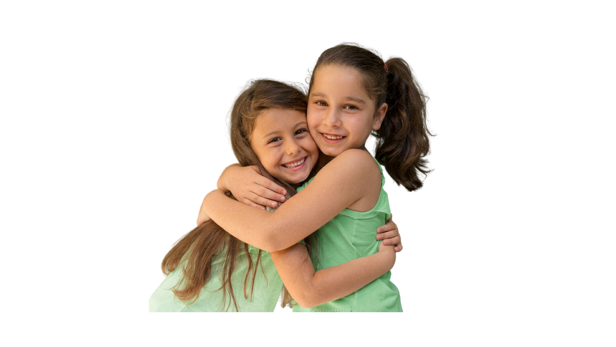 Two young girls hugging each other, smiling, wearing green tops and with long brown hair.