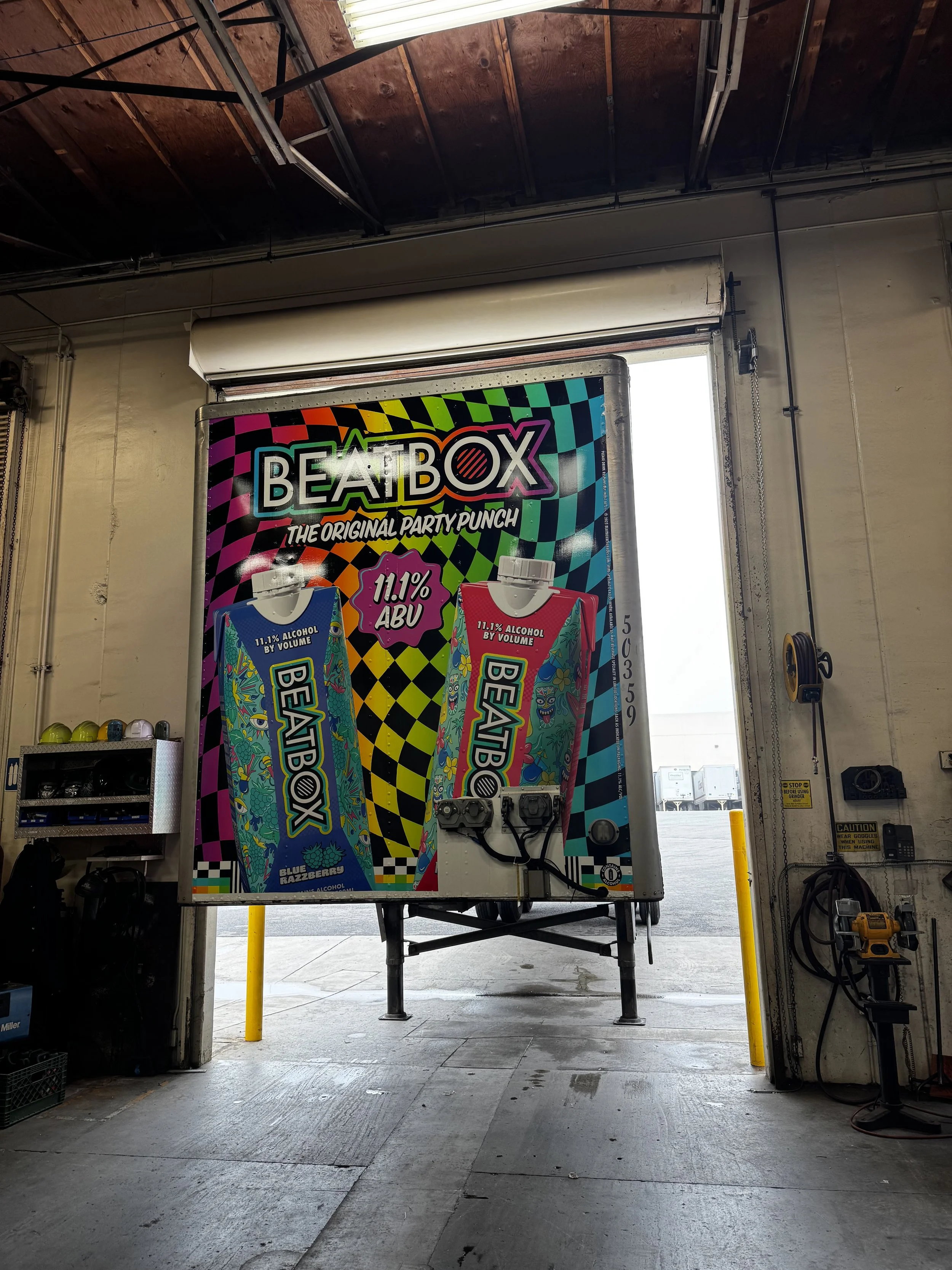 Colorful vending machine advertising BeatBox alcoholic beverage with cans featuring bright abstract designs and 11.1% alcohol by volume.