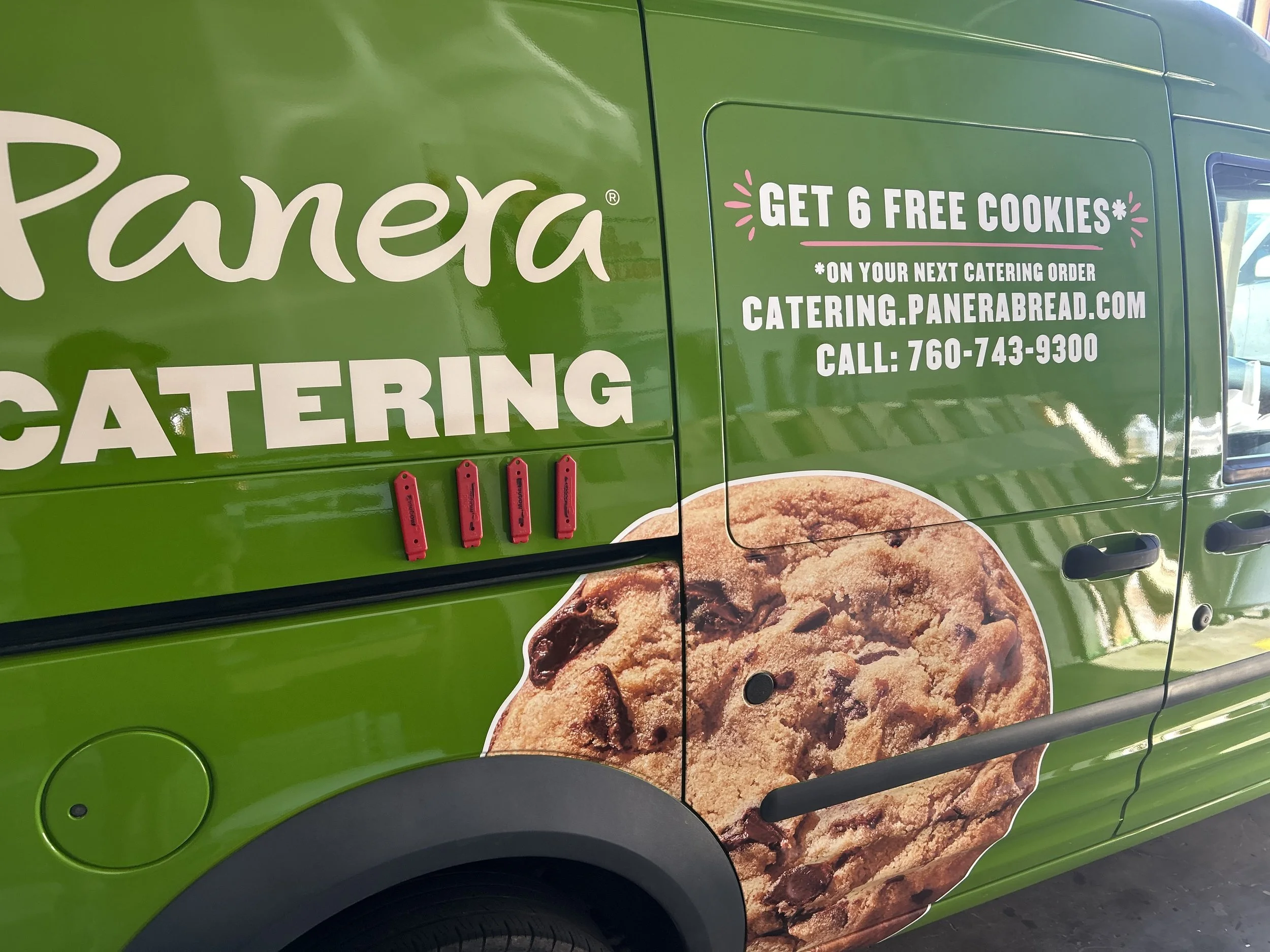 Green catering truck with a large cookie image and promotional text offering free cookies with catering orders.