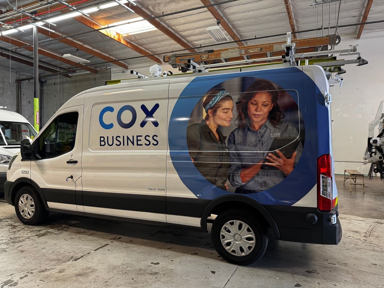 COX BUSINESS branded van with an image of two women looking at a tablet on the side