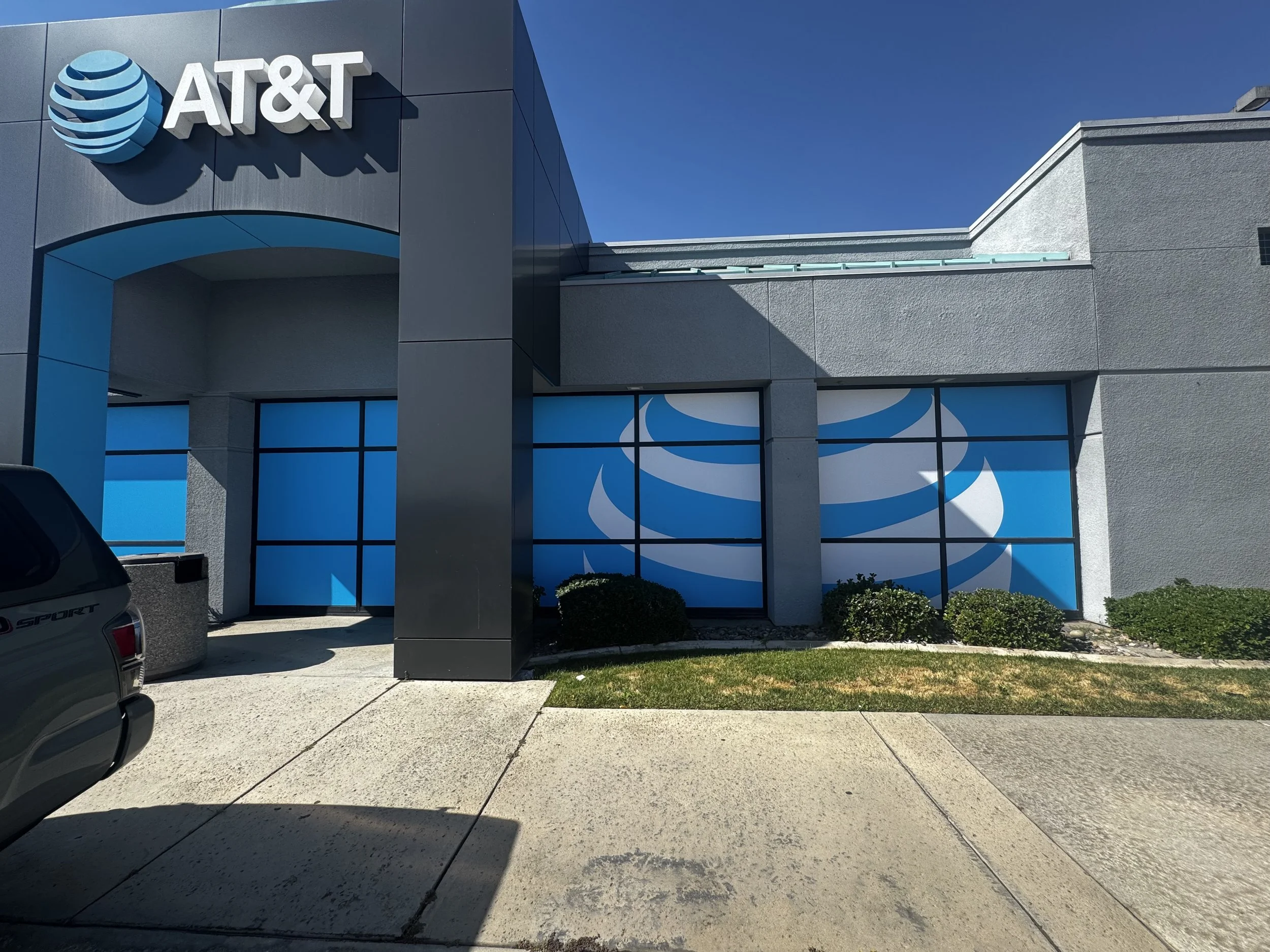 The exterior of an AT&T store with blue window panels displaying the AT&T logo and branding.