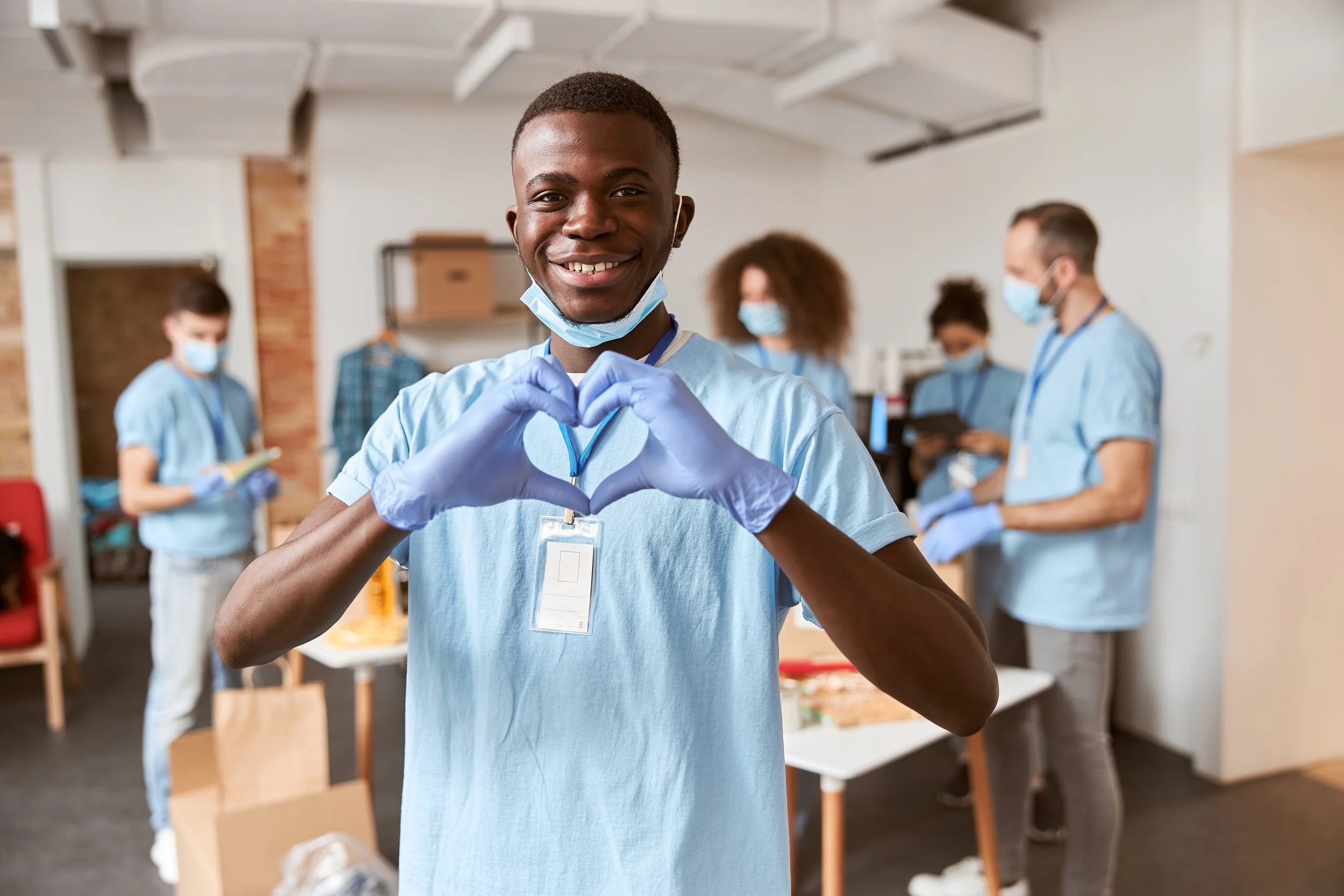 Young man volunteering with heart hands.