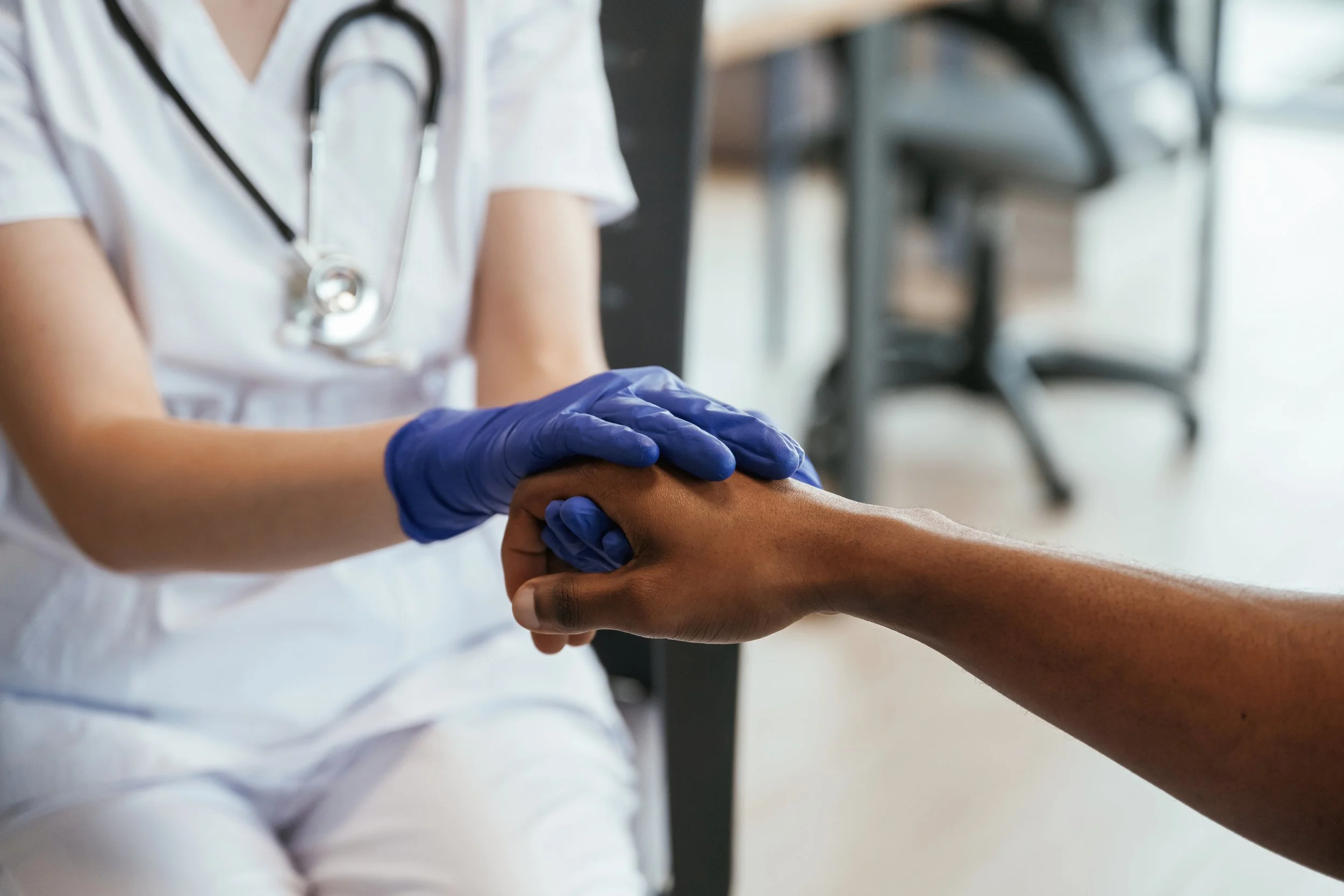 Doctor is holding patient hand.