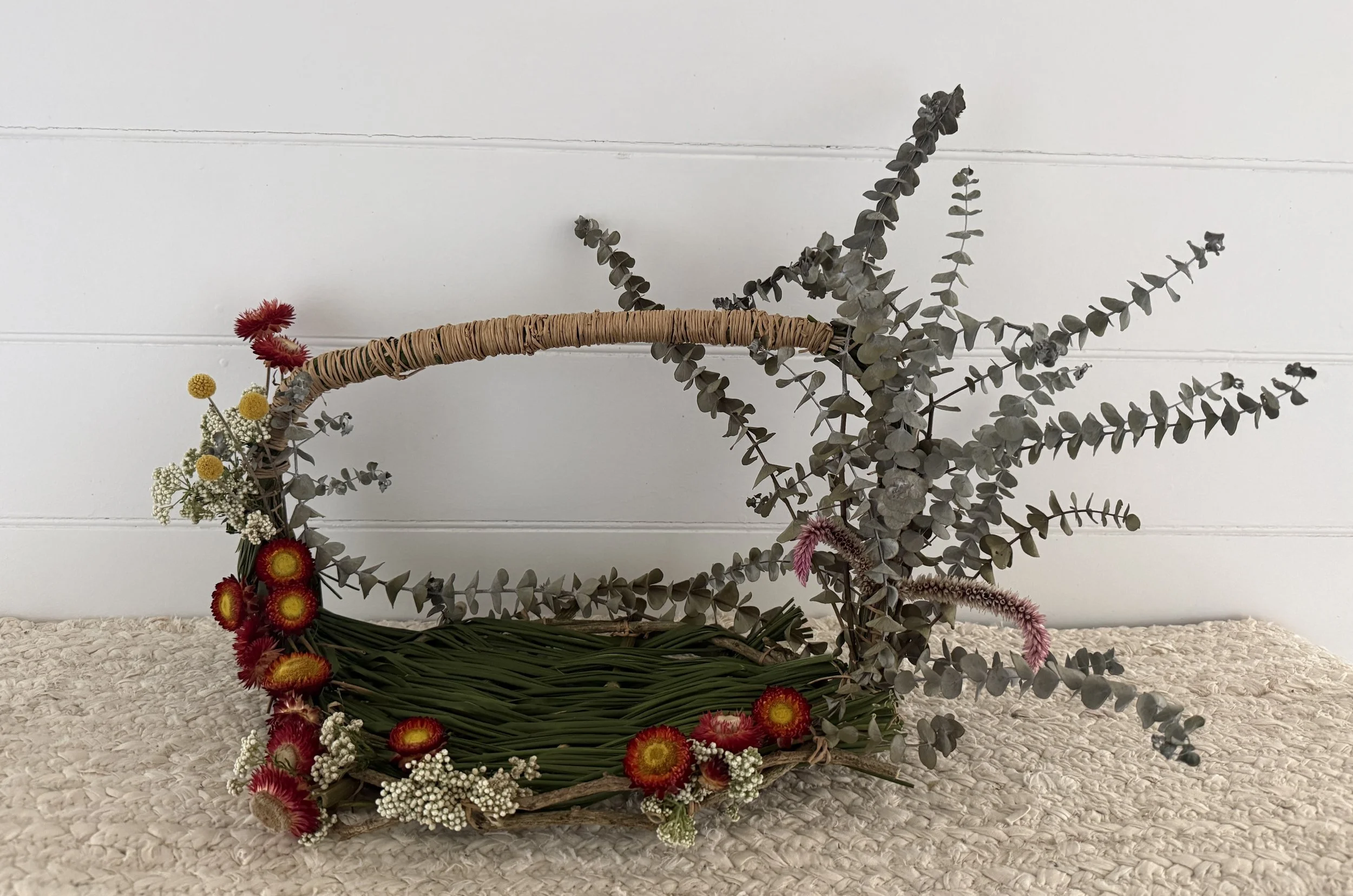 A decorative basket made of natural materials and Australian native flowers and foliage.