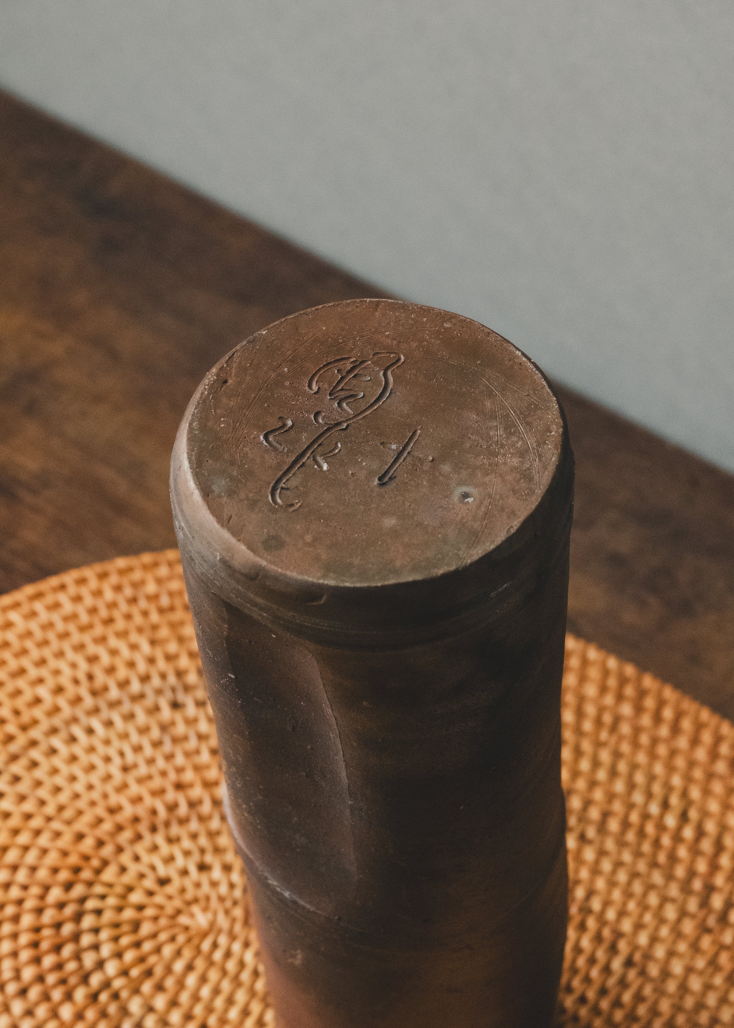 Close-up of a sharp, hand-incised master potter's mark on the base of an anonymous high-vintage Bizen ceramic sculpture.