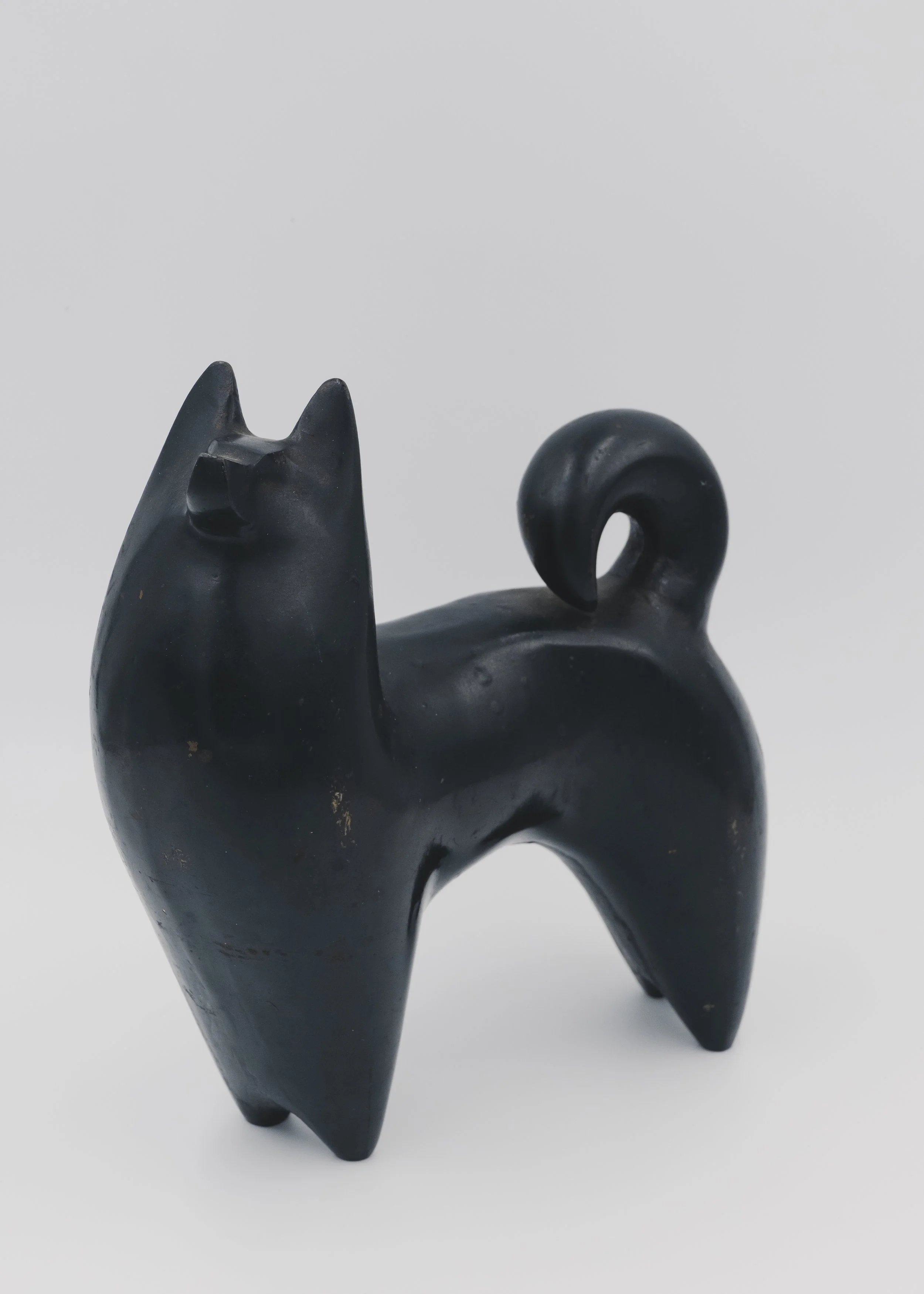 Close-up of the rough 'Ihada' (cast skin) texture and hand-applied Urushi lacquer on a solid iron Japanese guardian dog from the Mid-Showa era.