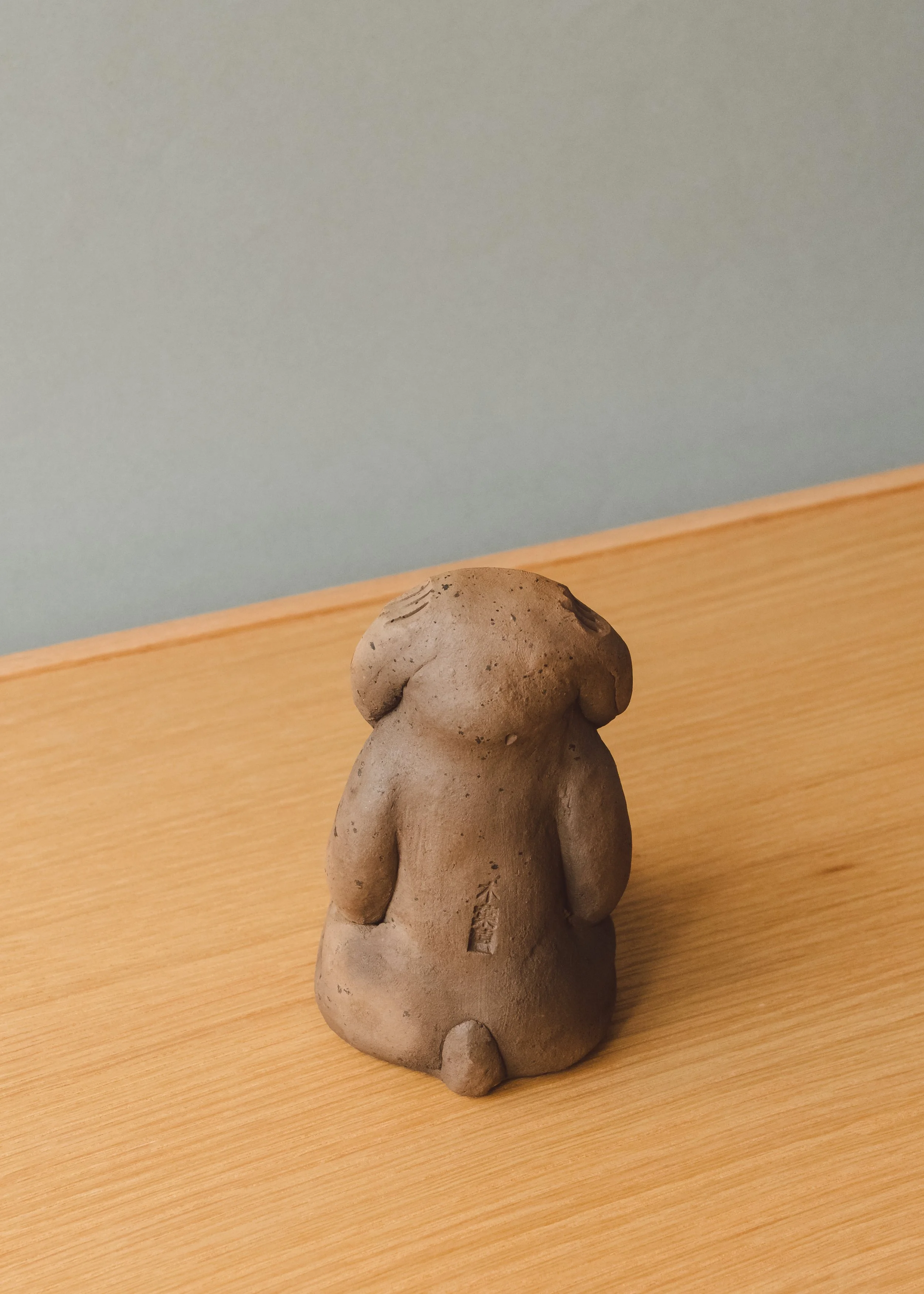 Vintage Japanese folk art "Speak No Evil" monkey talisman. The Brutalist and minimalist clay form functions as an intellectual conversation piece for contemporary desktop styling.