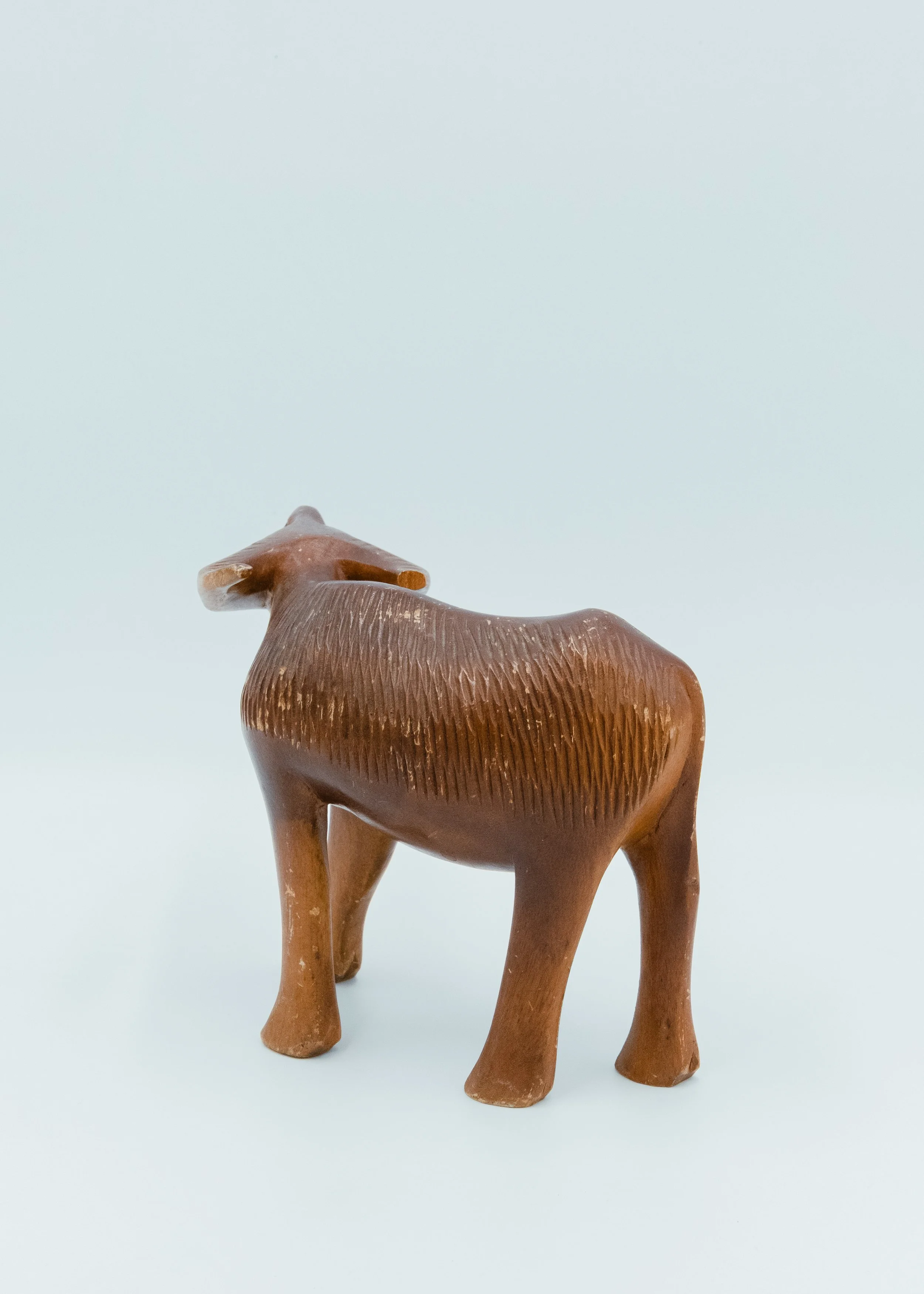 Back view of hand-carved wooden buffalo Japanese folk craft mingei object showing rough texture and patina