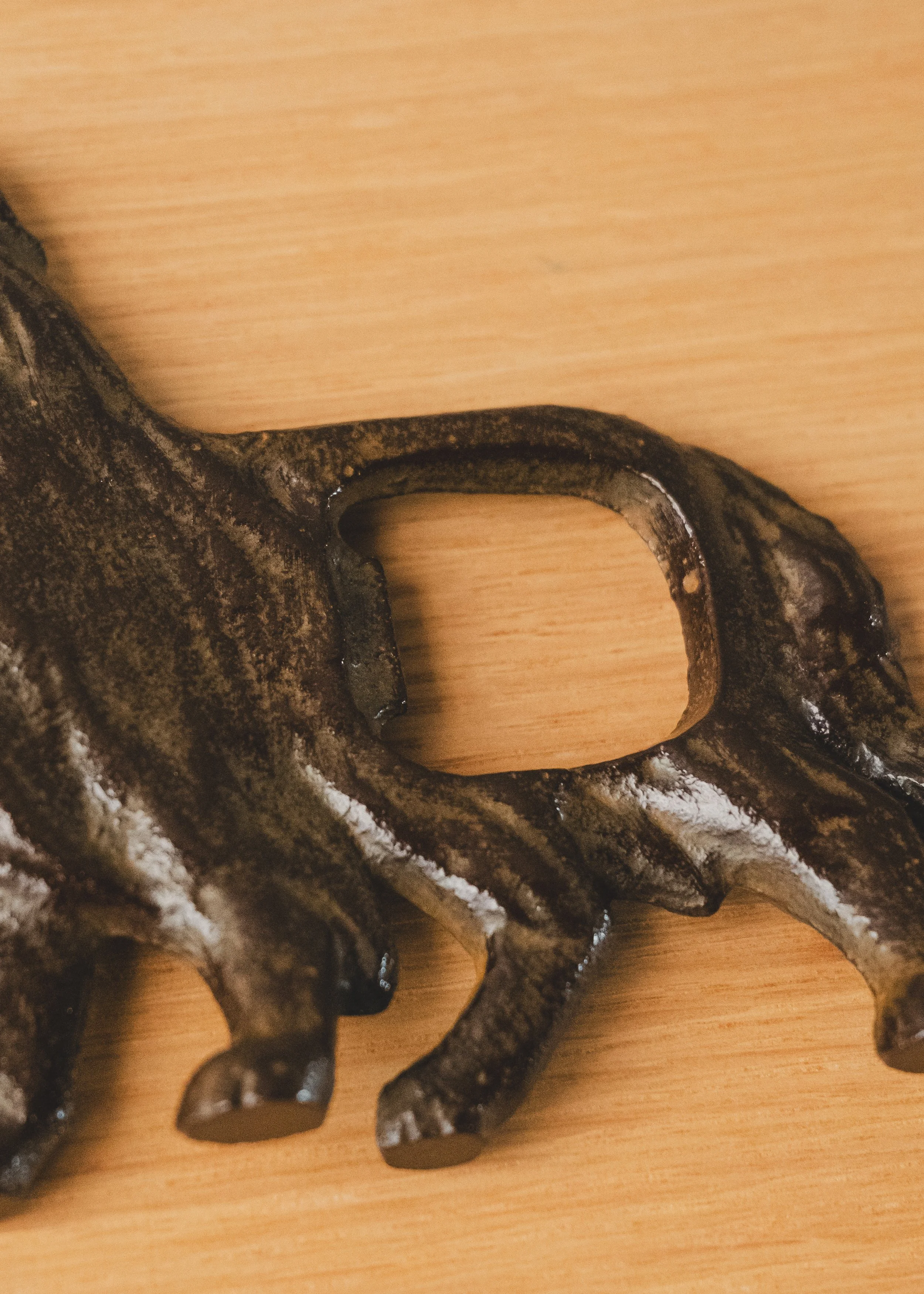 Ergonomic bottle opener functionality integrated into a Nambu iron dog. A dual-purpose functional sculpture and paperweight for the minimalist workspace.