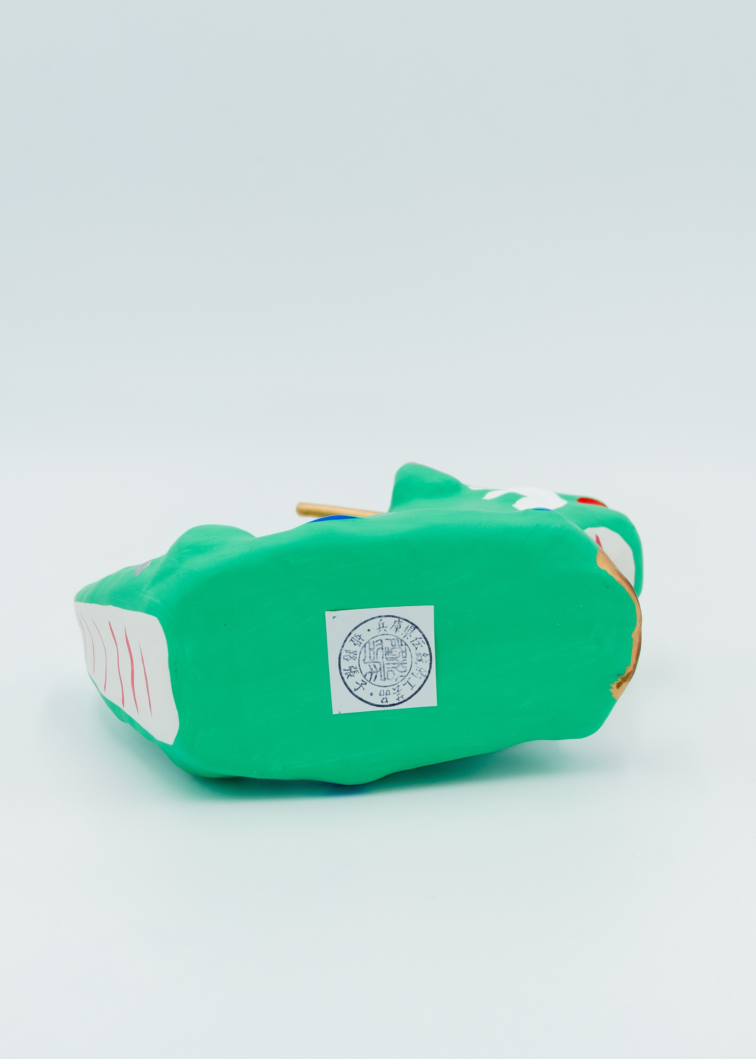 Bottom view of vintage hariko dragon showing traditional craft sticker authentic Himeji folk toy signature