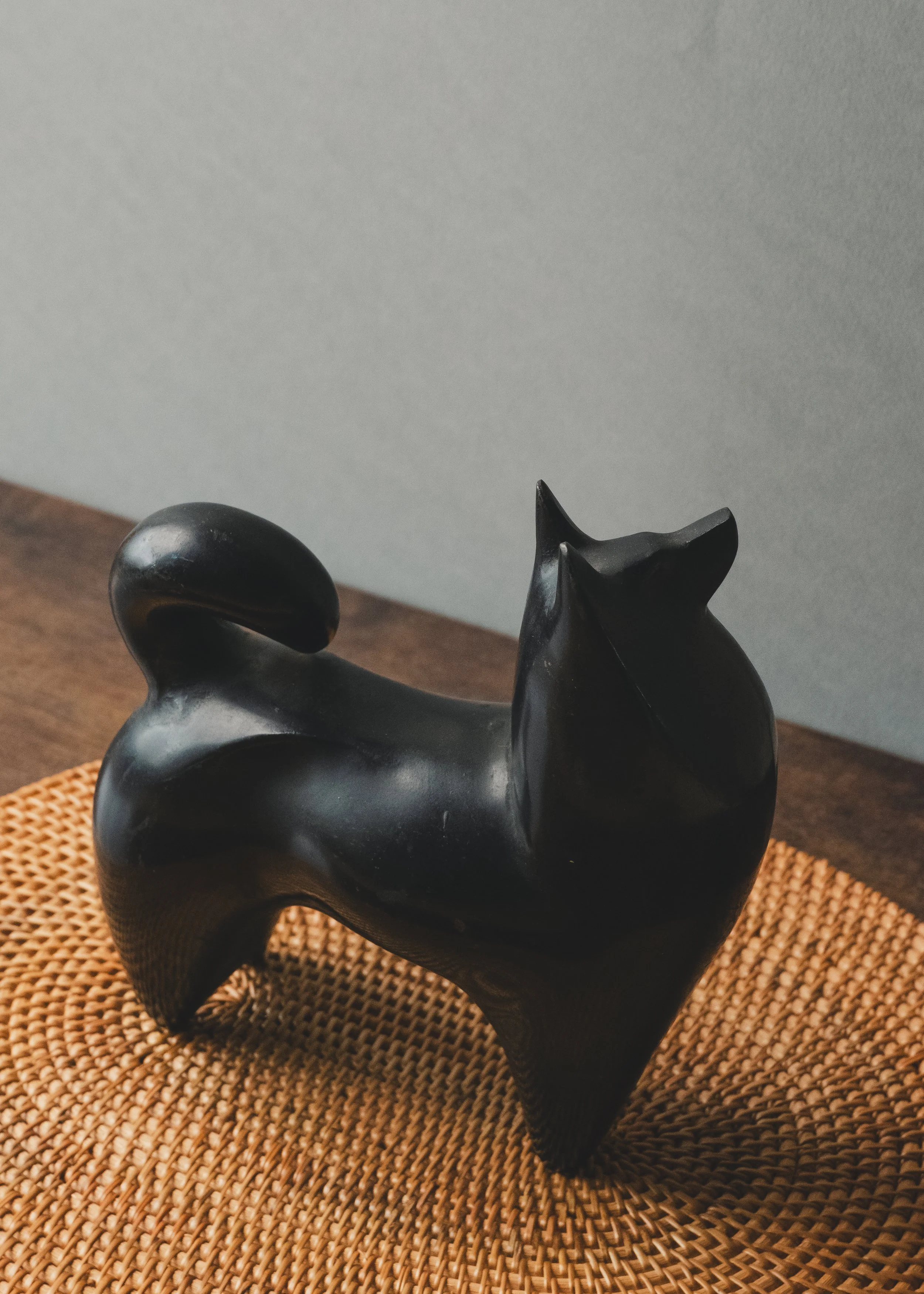 Modern minimalist Nambu Tekki iron dog figurine on a woven reed mat (tatami texture), showcasing spiritual gravity and wabi-sabi aesthetics.