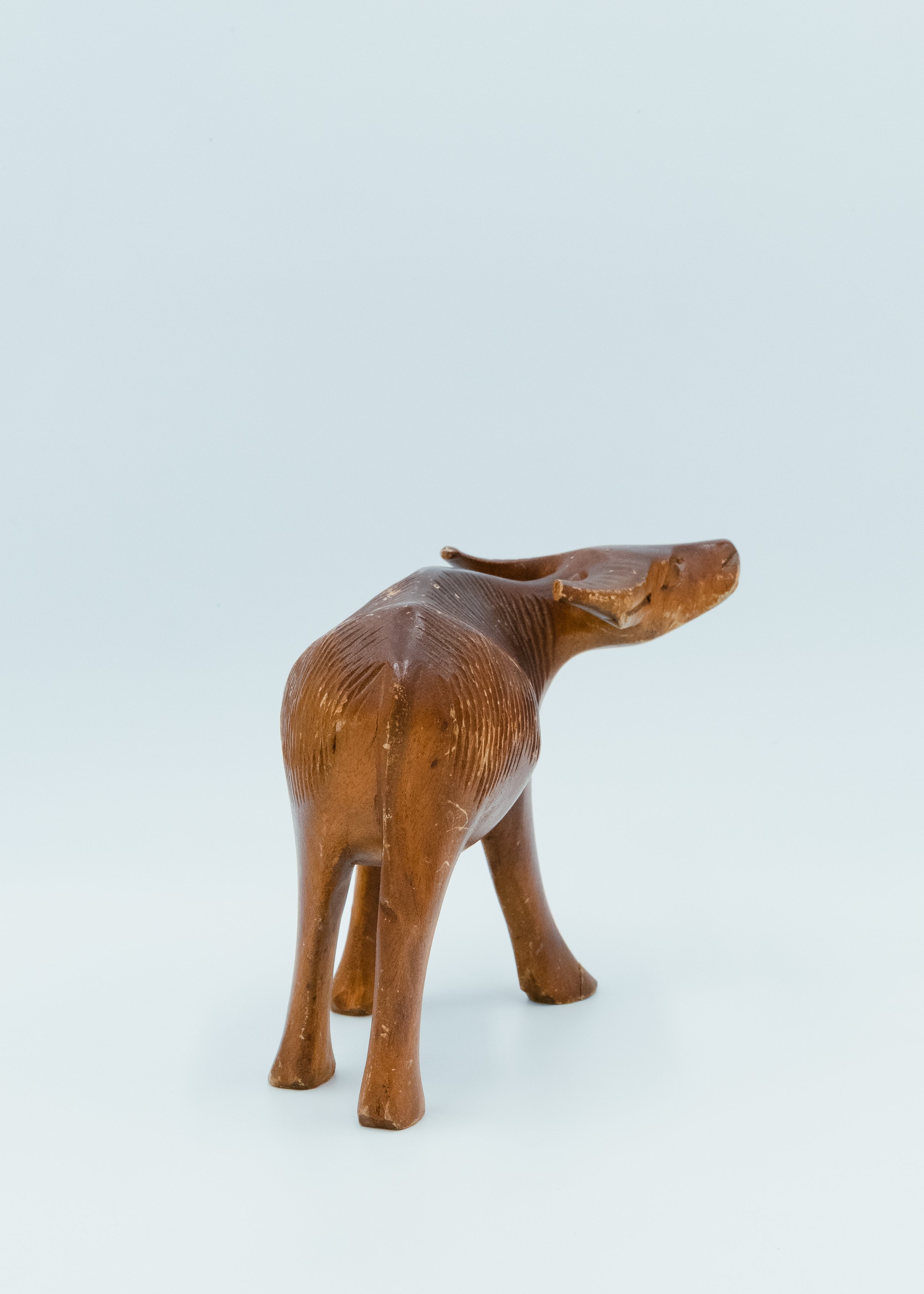 Back view of hand-carved wooden buffalo Japanese folk craft mingei object showing rough texture and patina