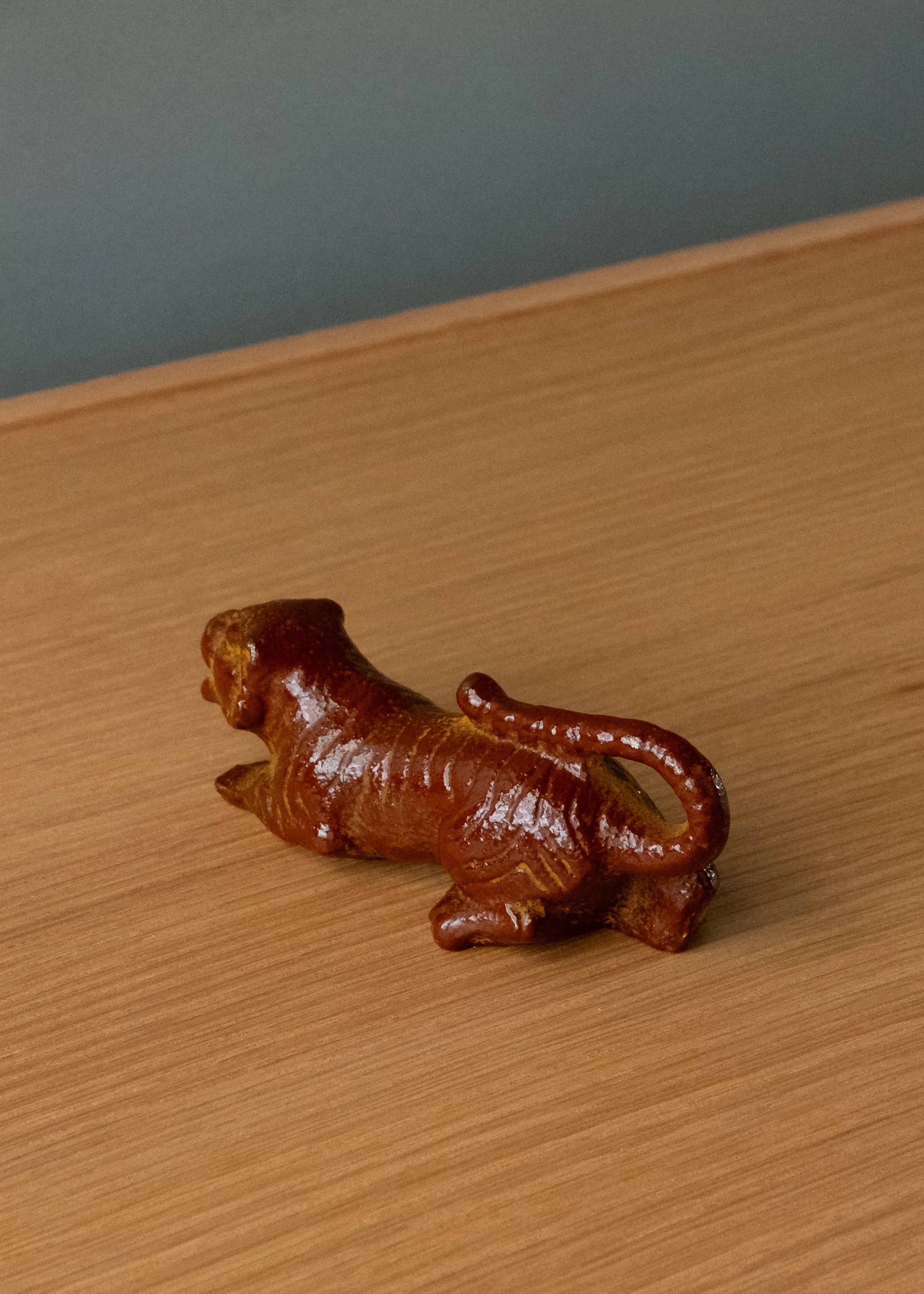 Nambu Tekki iron tiger sculpture. 1974 Showa modern paperweight with rare red iron-amber lacquer finish. View showing rhythmic ridges along the back for brush rest.