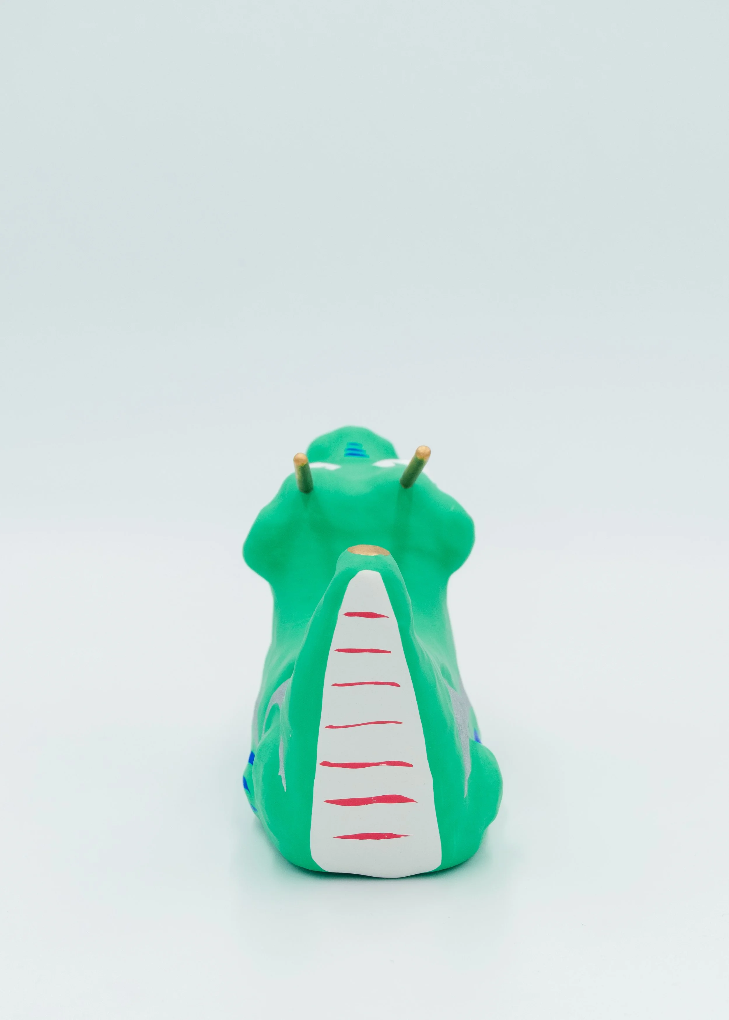 Back view of hand-painted paper dragon ornament vibrant green red white colors traditional pattern design