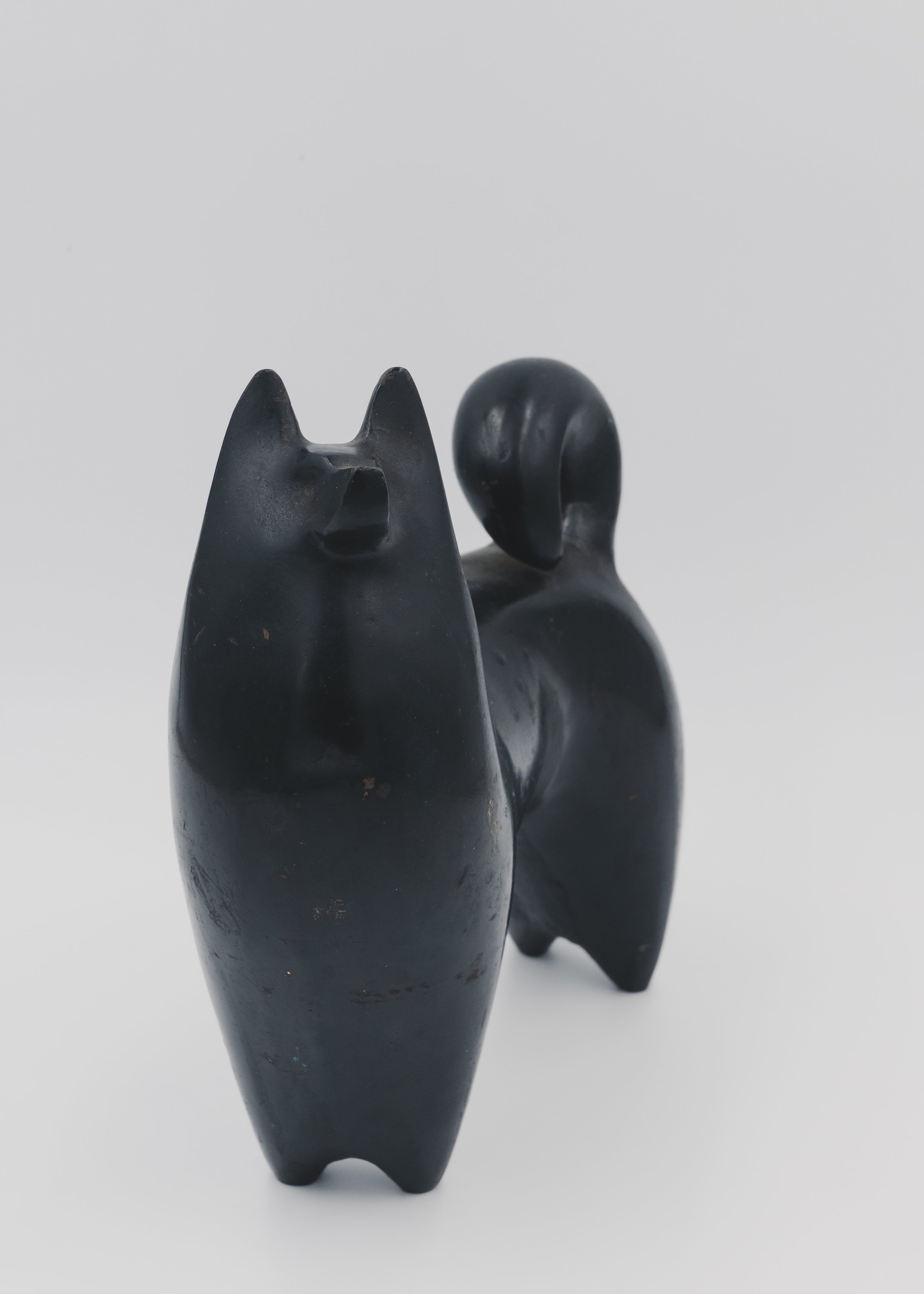 Close-up of the rough 'Ihada' (cast skin) texture and hand-applied Urushi lacquer on a solid iron Japanese guardian dog from the Mid-Showa era.