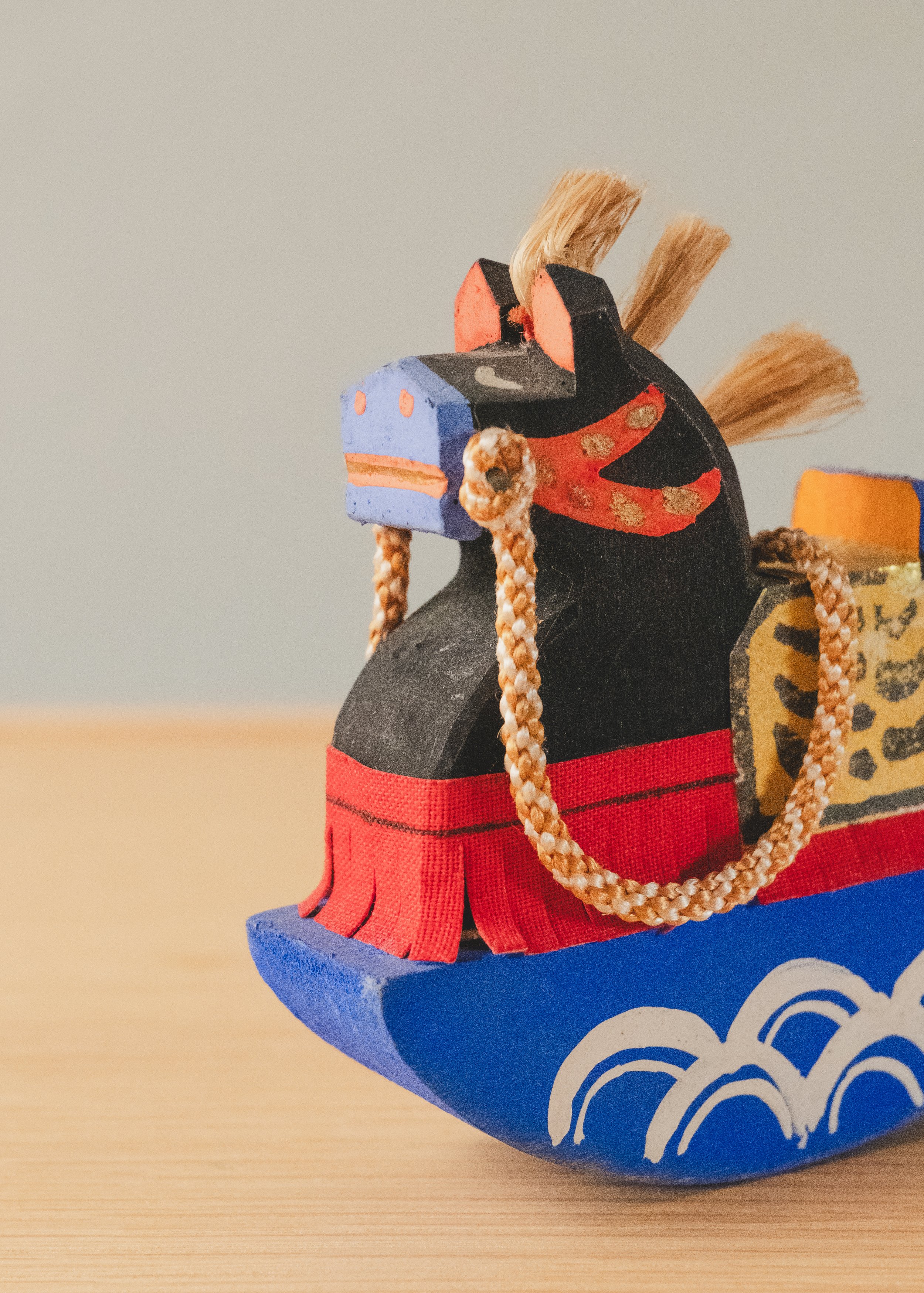 Macro close-up of the VANGUARD STALLION face, showcasing authentic hand-painted pigments on carved wood and traditional Japanese harness designs.