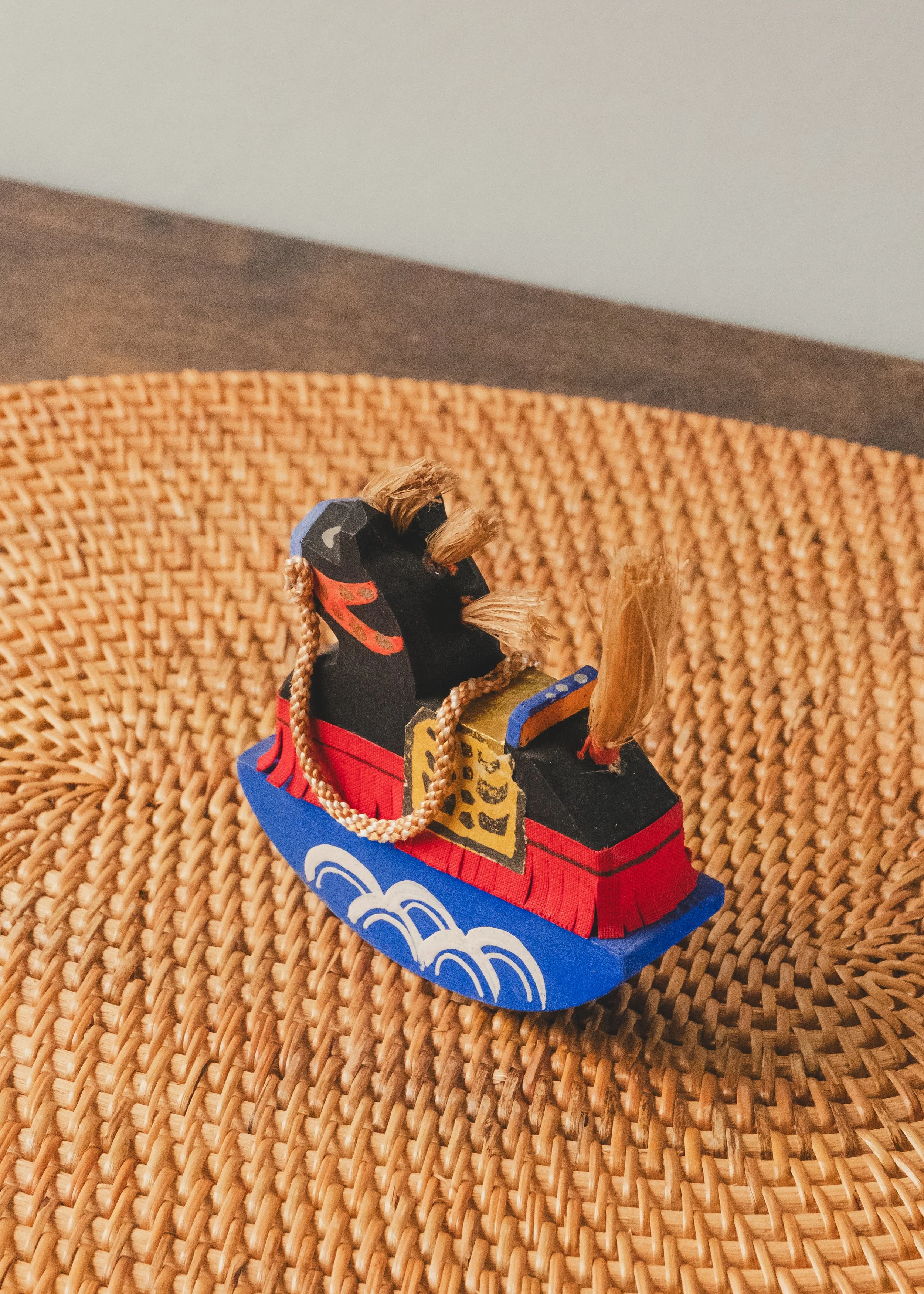 Rear perspective of THE VANGUARD STALLION 1930, a hand-carved vintage Japanese Paulownia wood horse with natural straw tail and a blue rocking pedestal.