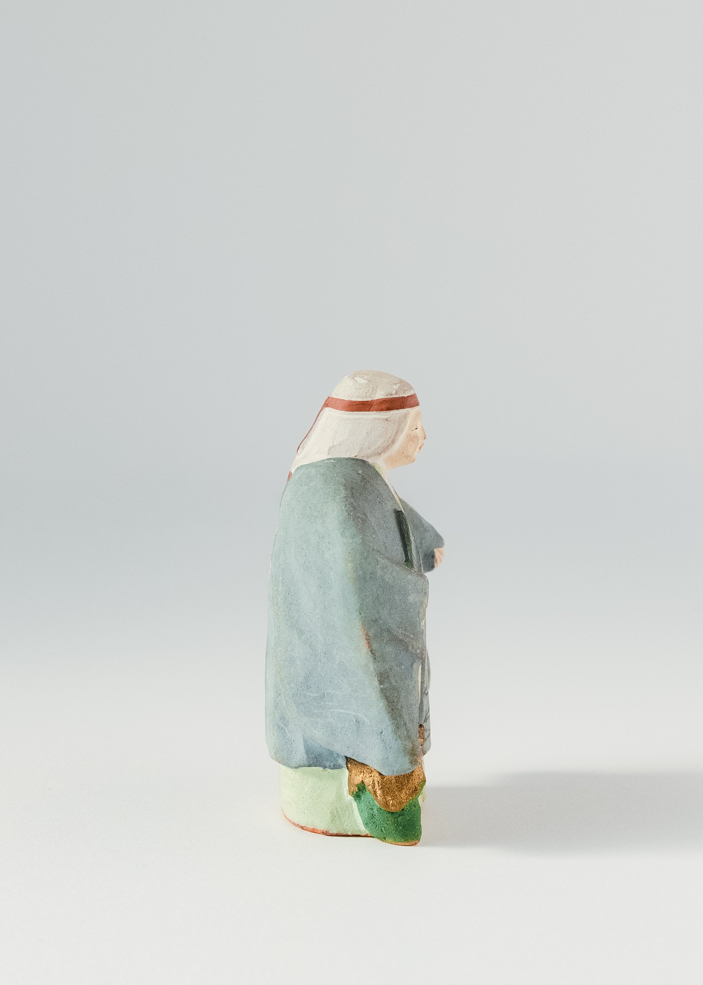 Side profile of Japanese clay god Jurōjin figurine folk pottery long life symbol monk with scroll