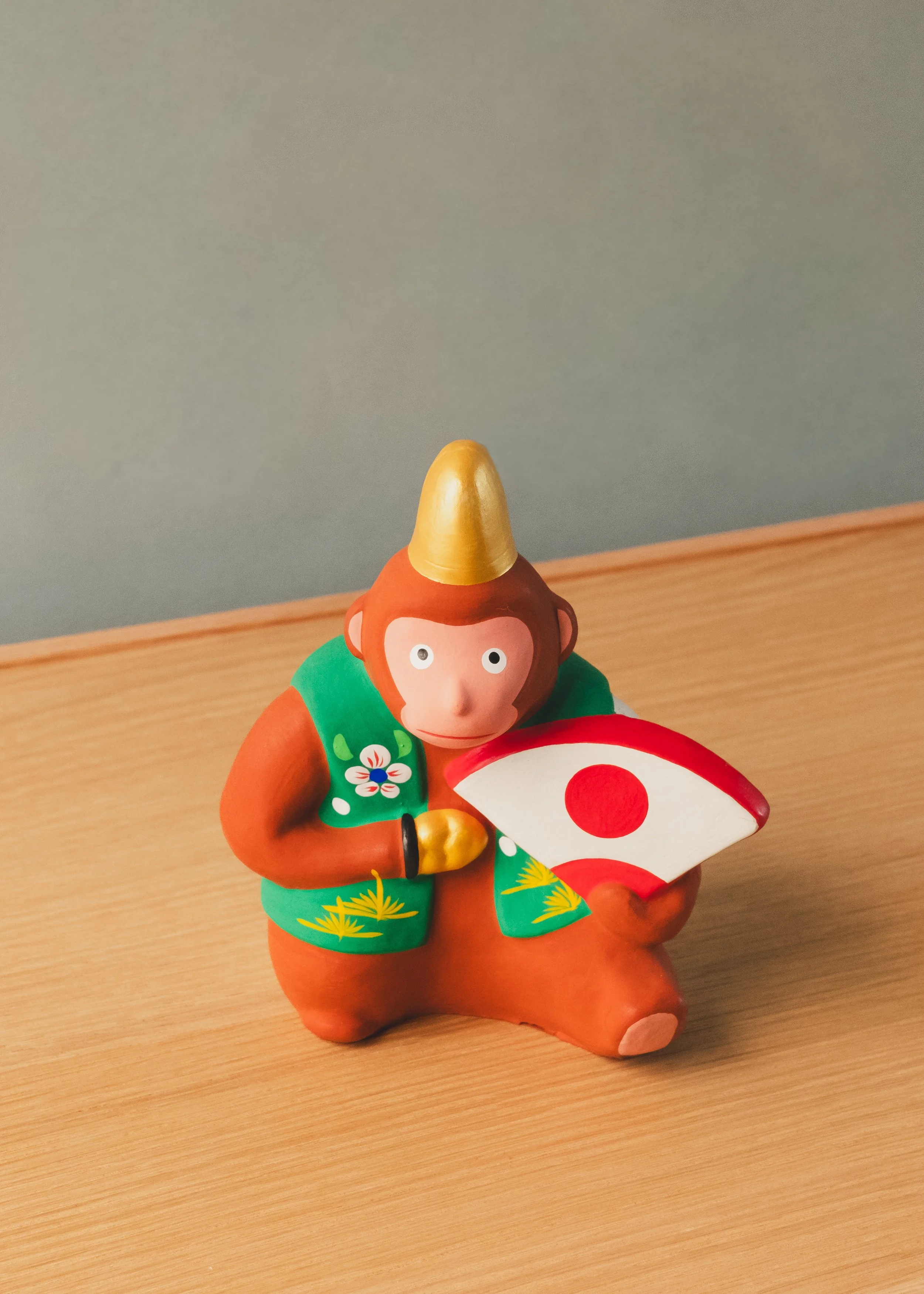 Hanamaki Ningyo clay monkey figurine. 1974 Japanese folk craft (Mingei) showcasing vibrant hand-painted robes and a celebratory fan.