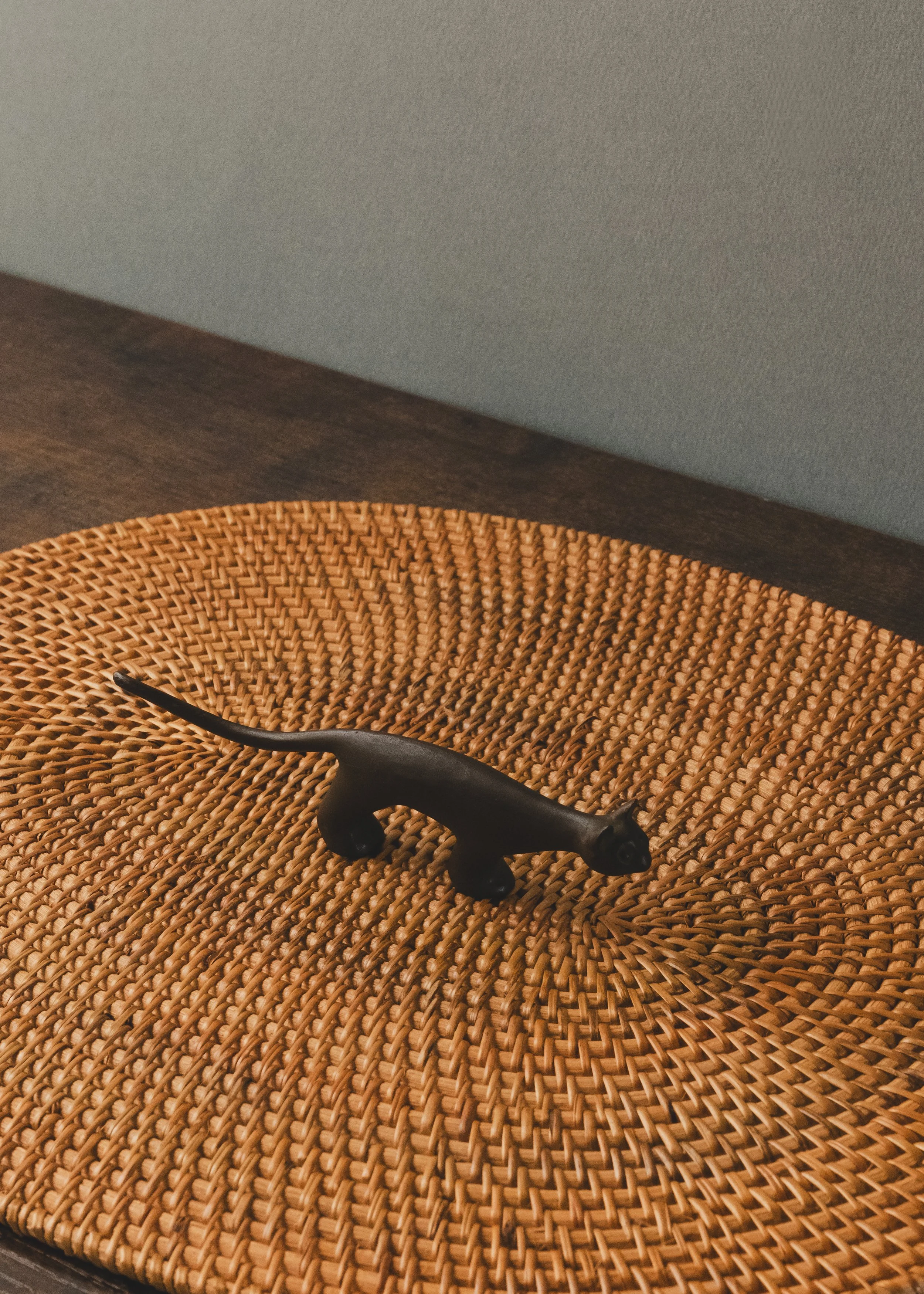 Rear view of a solid iron feline figurine showing the traditional "Sabiiro" oxidized patina. Sleek modernist form doubling as a paperweight or ring valet.