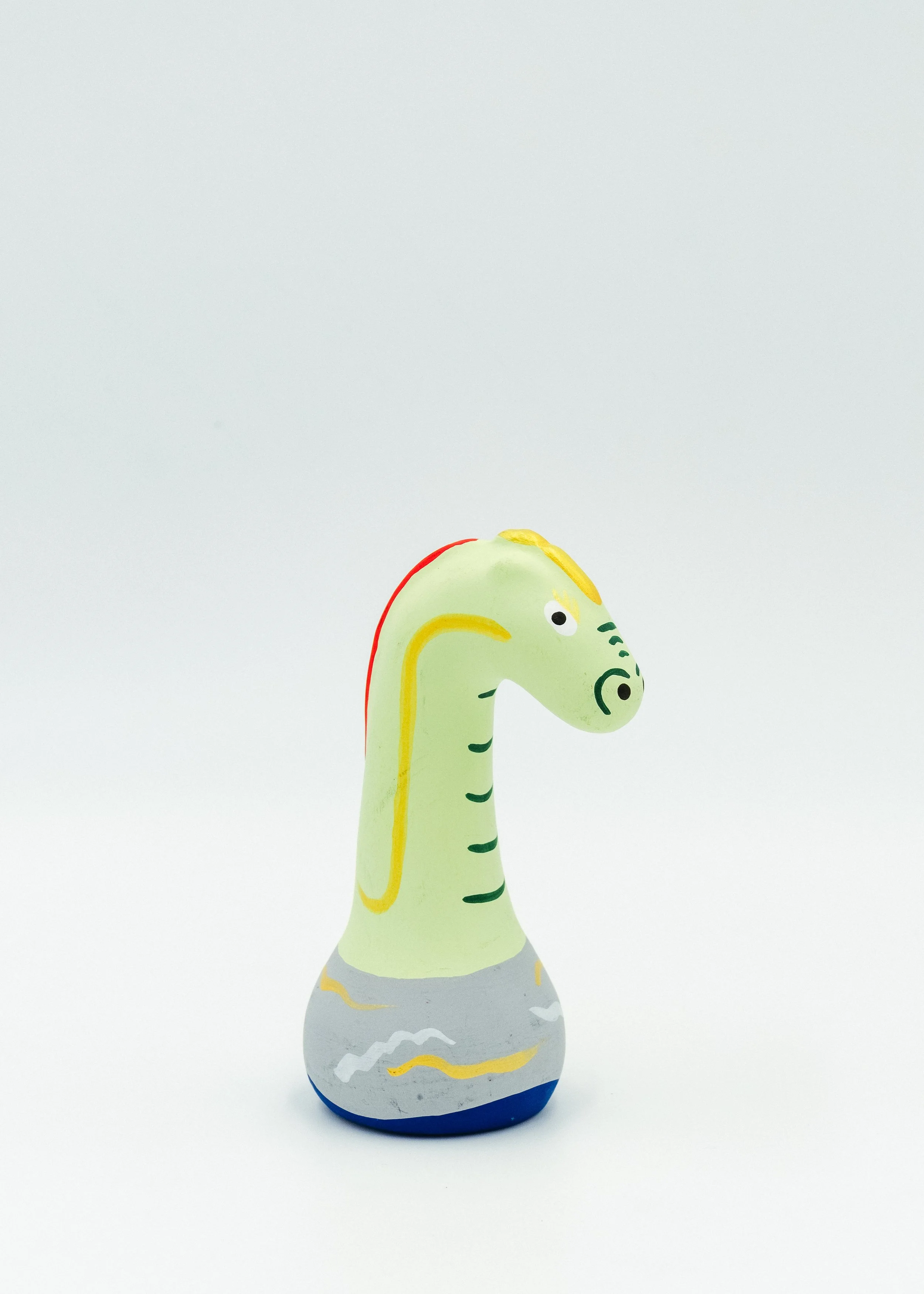 Side profile of long neck dragon figurine vintage Japanese mingei folk toy Shiga craftsmanship surreal design