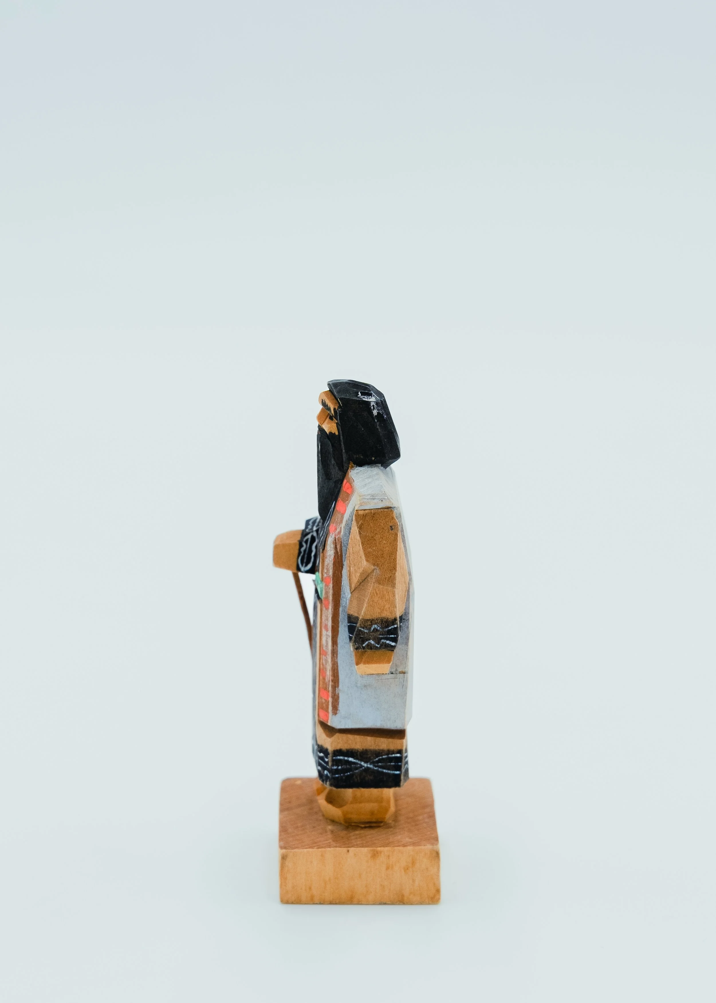 Side view of vintage Ainu wood carving doll carrying wooden backpack traveler figure Hokkaido folk art