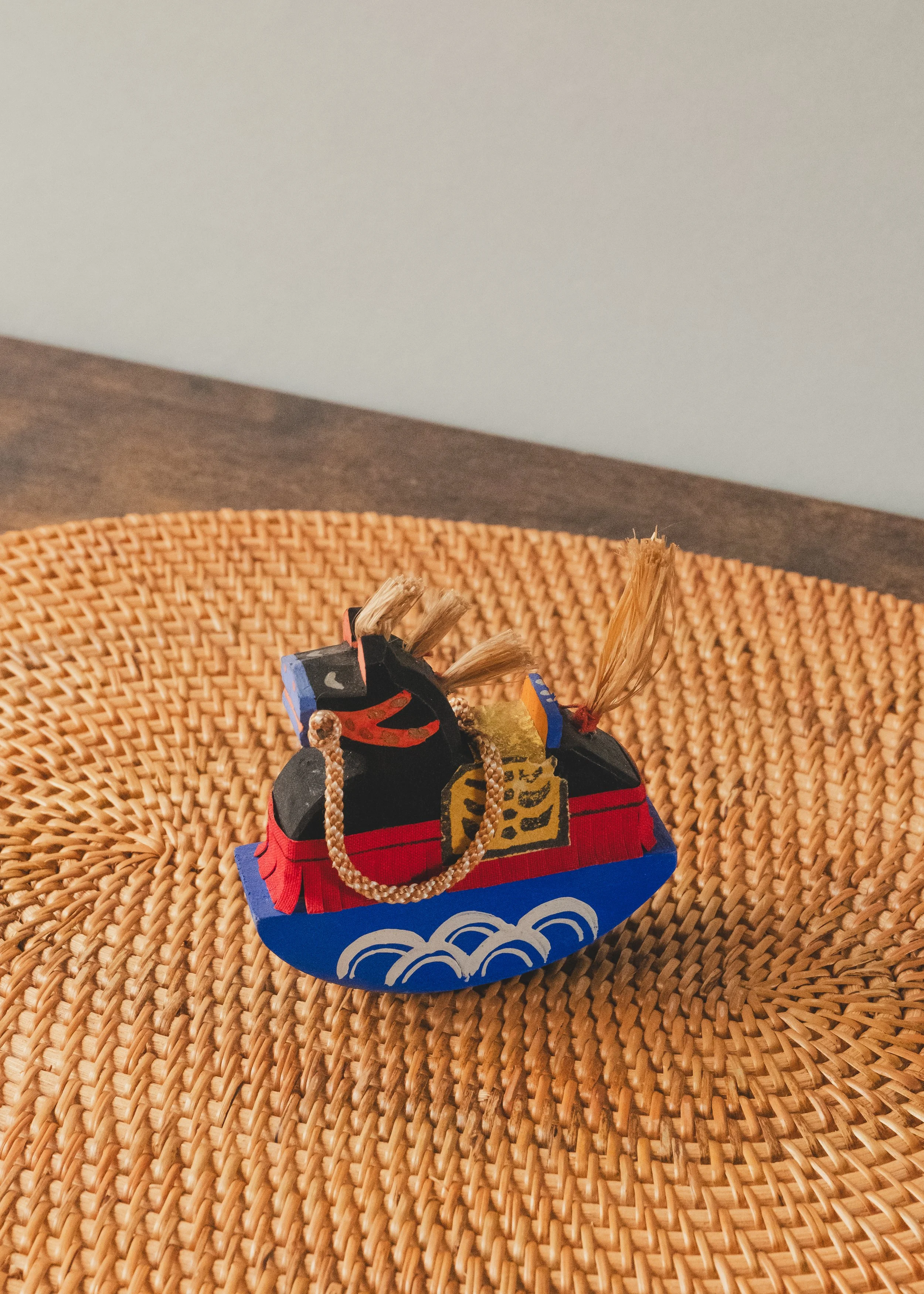 Three-quarter view of the VANGUARD STALLION 1930 sculpture, showing its minimalist black wooden body and vibrant hand-painted Japanese Mingei details.