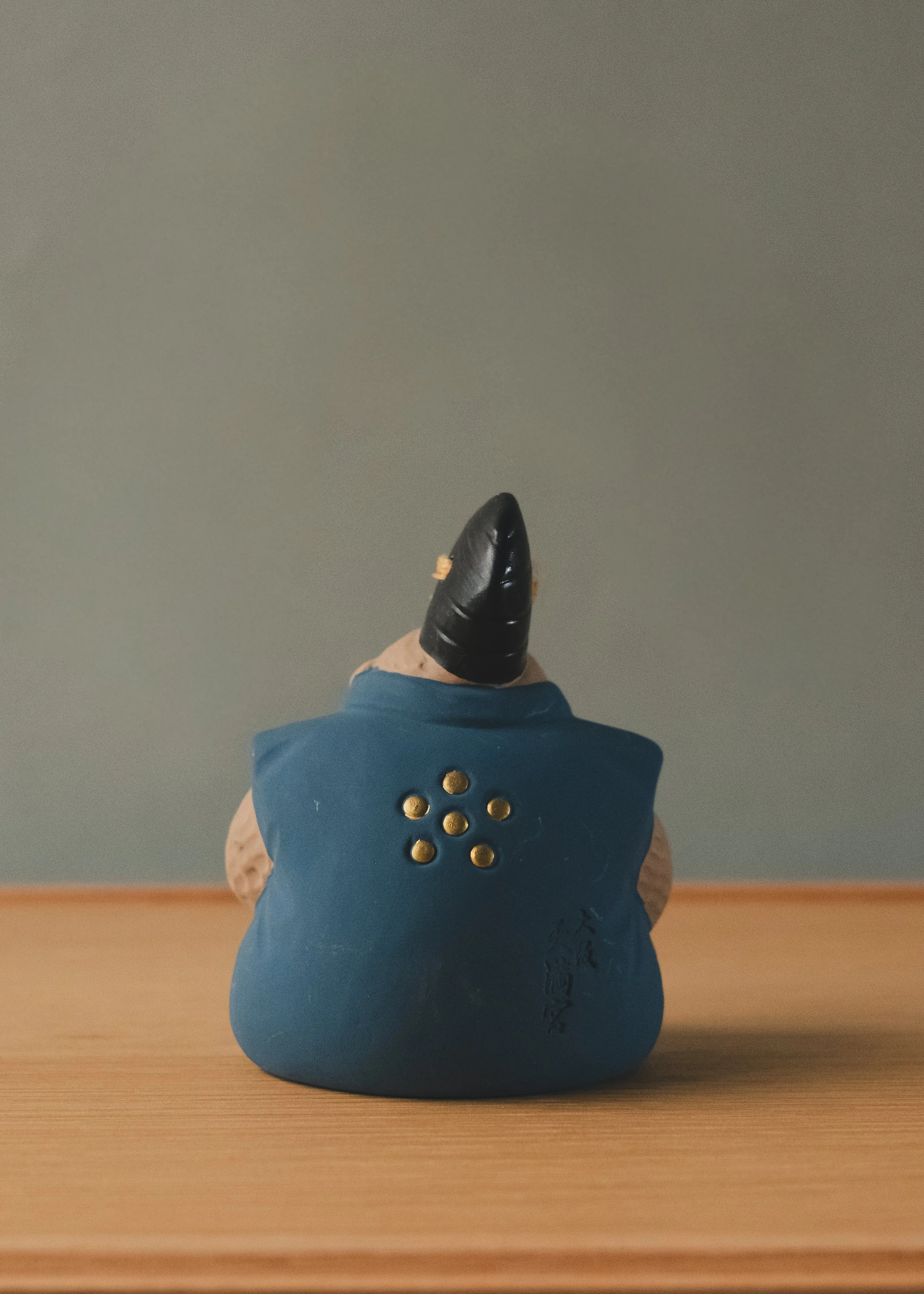 Rear view of a Japanese monkey amulet featuring the golden Ume-mon (Plum Blossom) crest of Osaka Tenmangu. An authentic specimen of Mingei folk tradition.