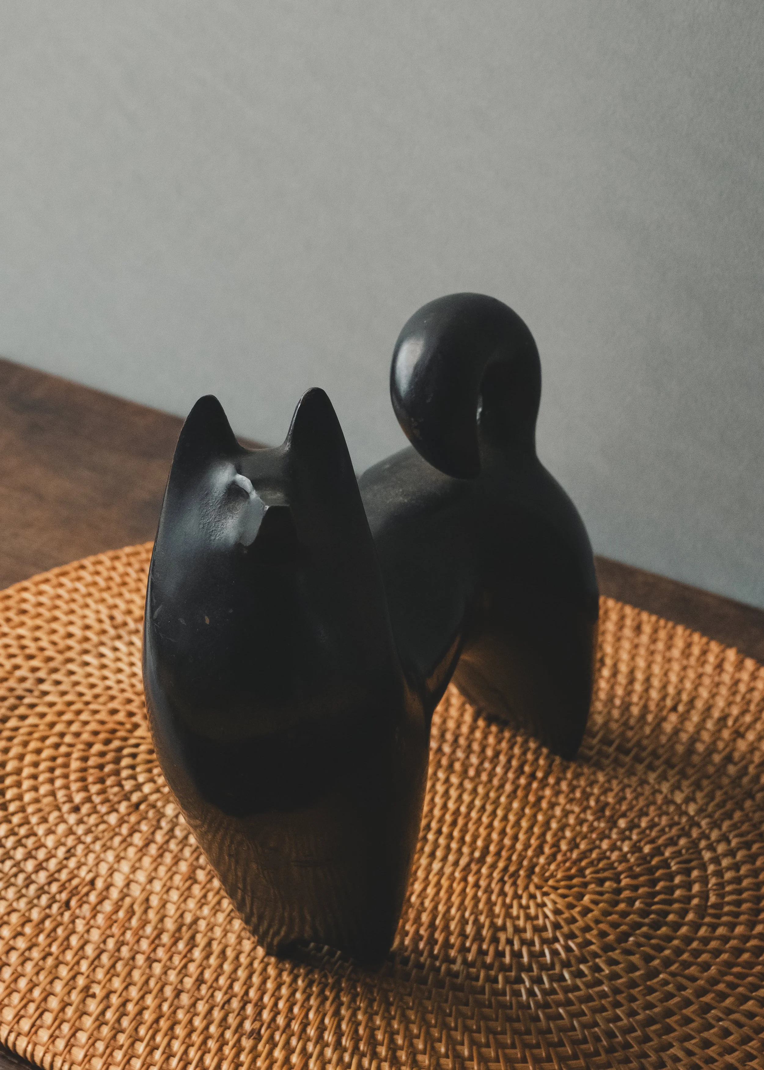 Modern minimalist Nambu Tekki iron dog figurine on a woven reed mat (tatami texture), showcasing spiritual gravity and wabi-sabi aesthetics.