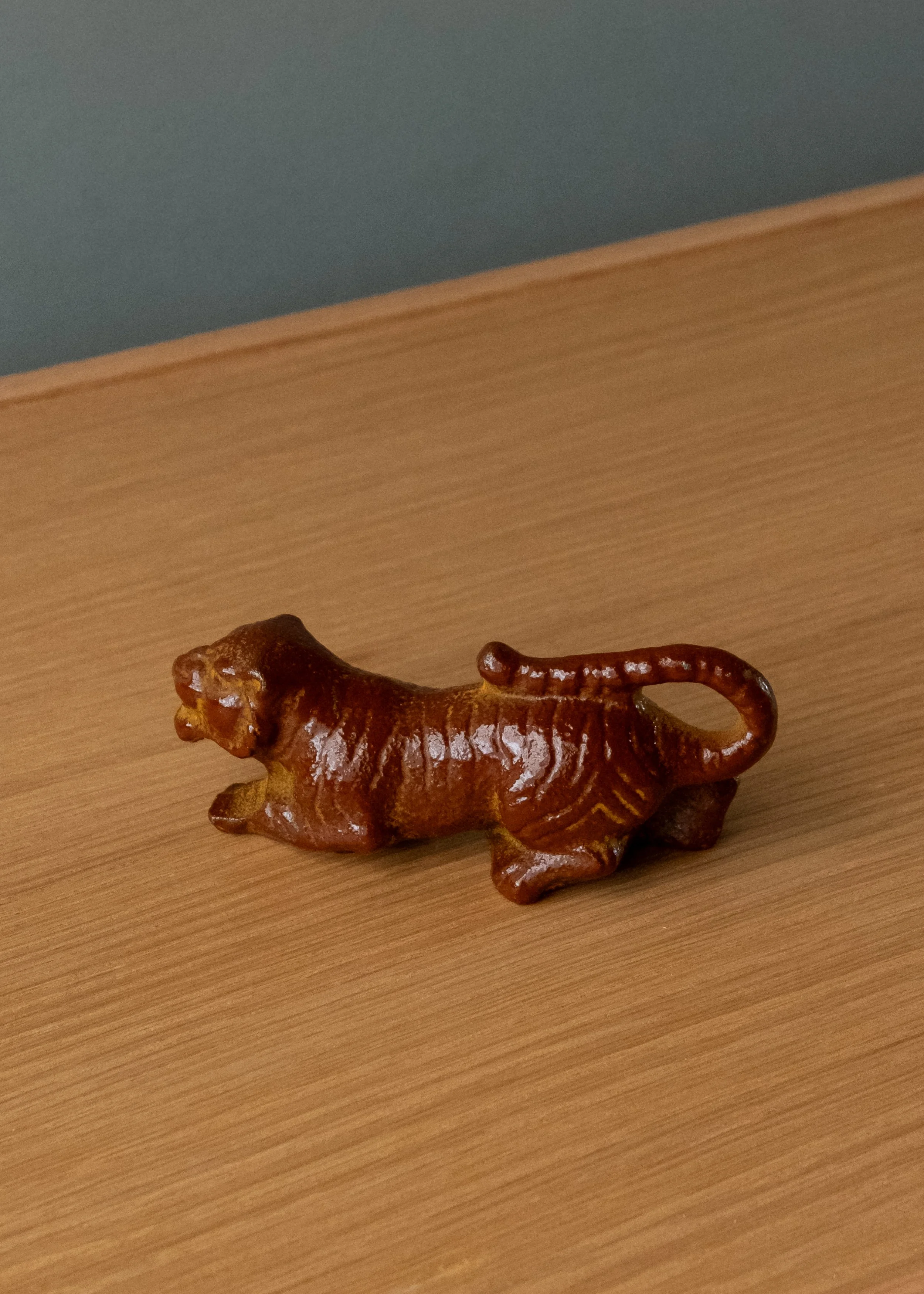 Antique Nambu Tekki iron tiger bottle opener and sculpture. Detail of the celestial stripe texture in reddish-brown vitrified luster. Handmade Japanese desk anchor.