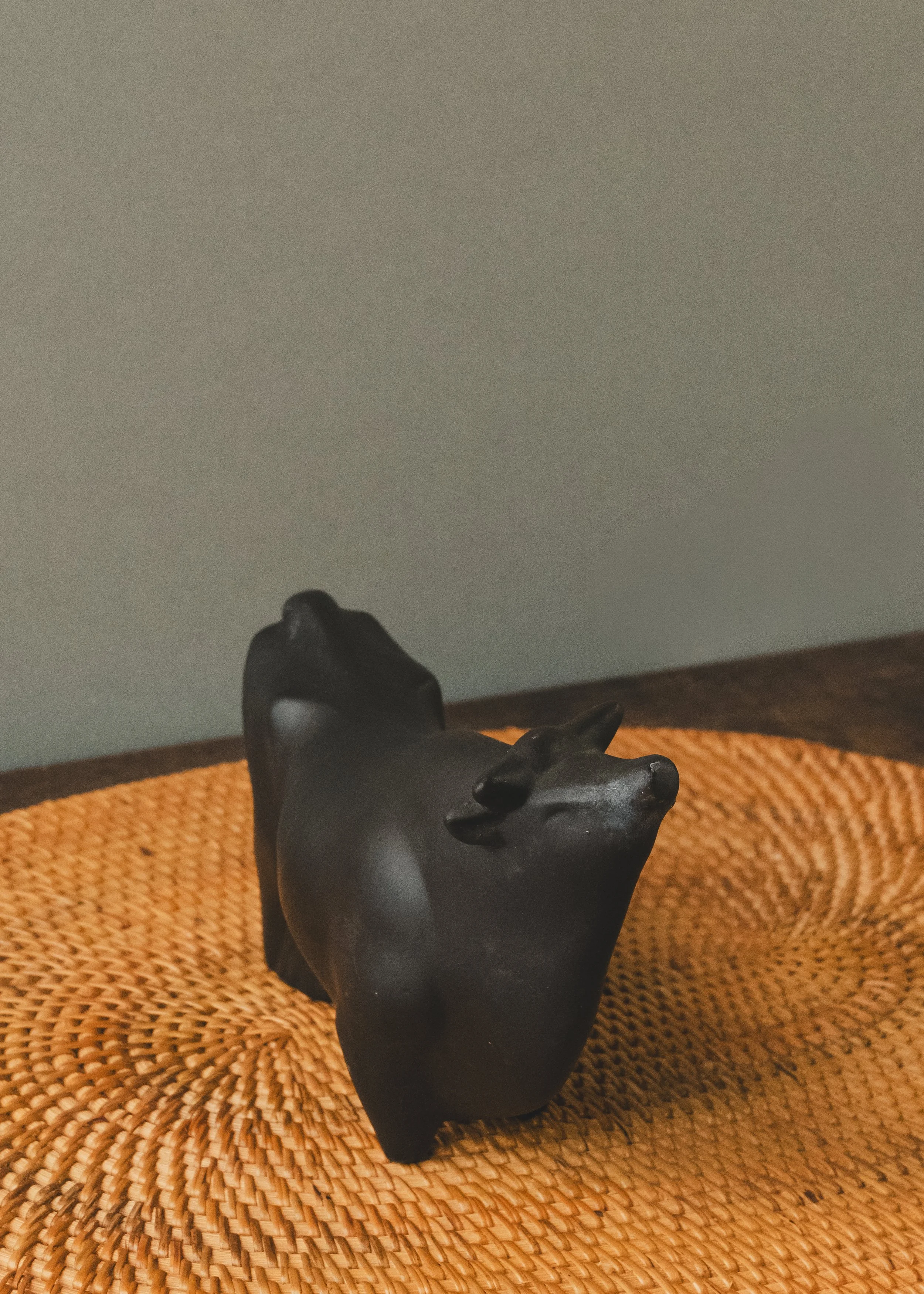 Minimalist Japanese black pottery bull sculpture, 1968. A matte-finish, handcrafted desk sentinel for the modern workspace. High-density clay artifact from Northern Japan.