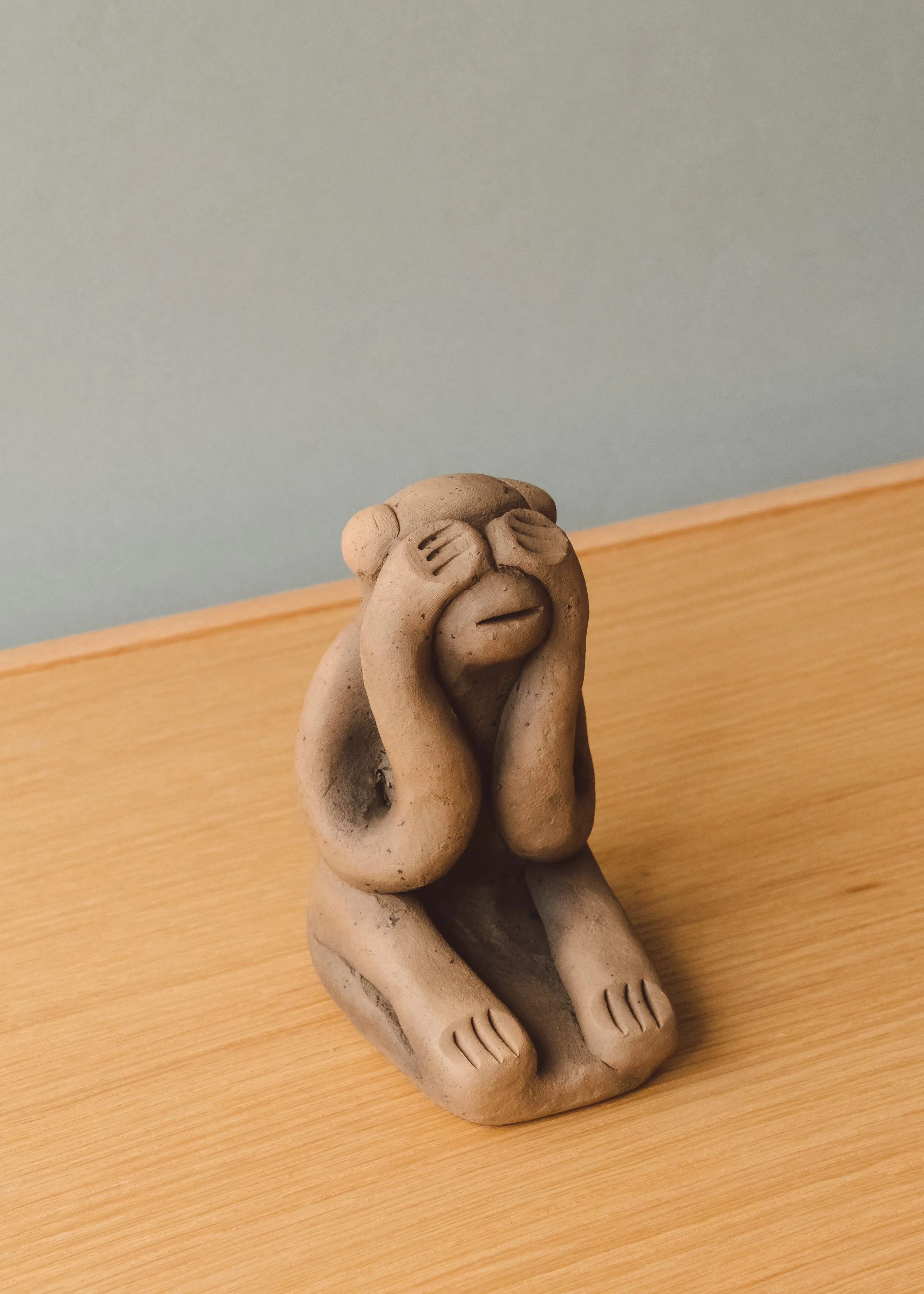 Close up of a 1960s Japanese clay guardian monkey (See No Evil). Features a rugged, finger-pinched surface characteristic of primitive Zen aesthetics, sourced from an authentic Mingei archive.