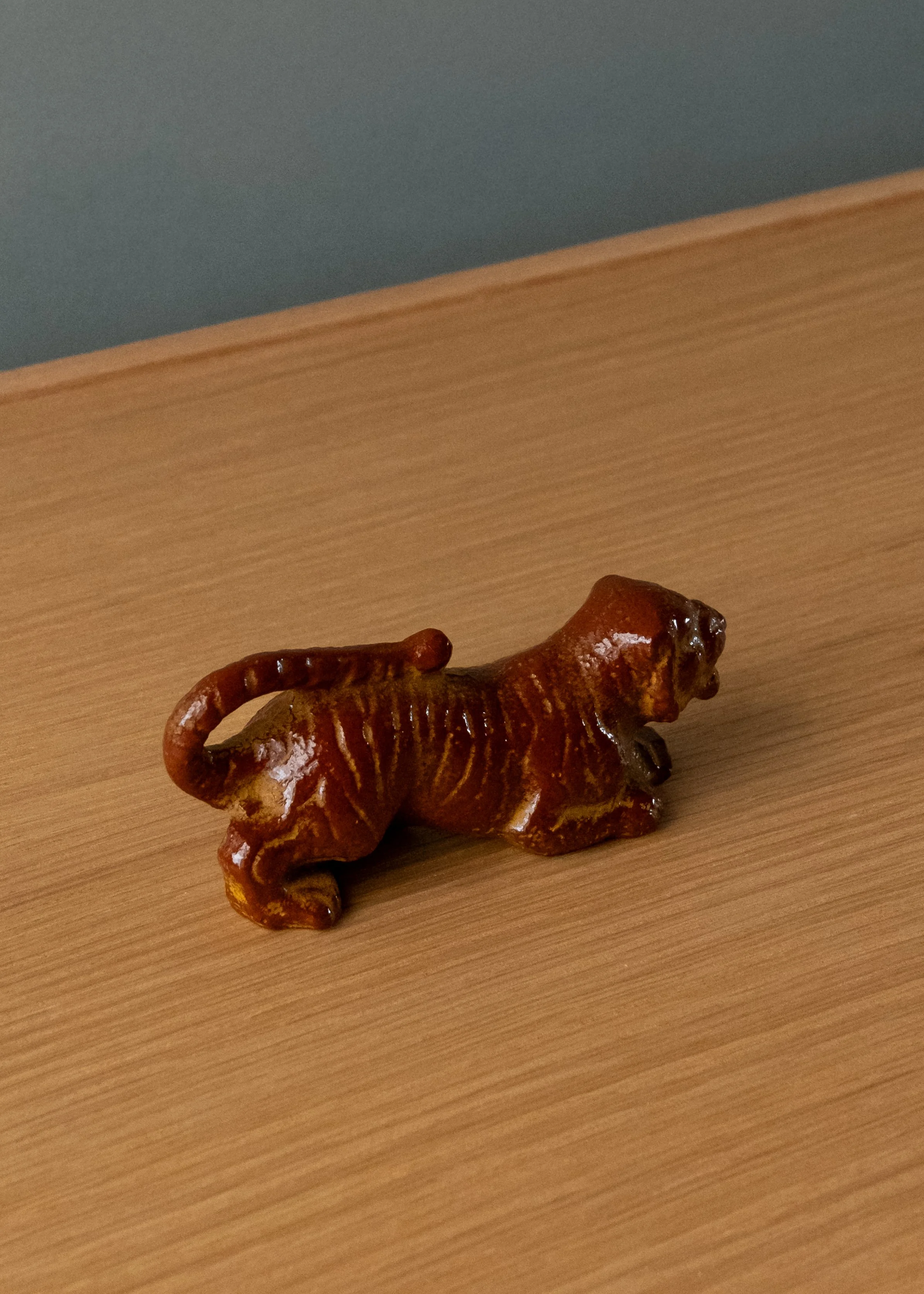 Nambu Tekki iron tiger sculpture. 1974 Showa modern paperweight with rare red iron-amber lacquer finish. View showing rhythmic ridges along the back for brush rest.