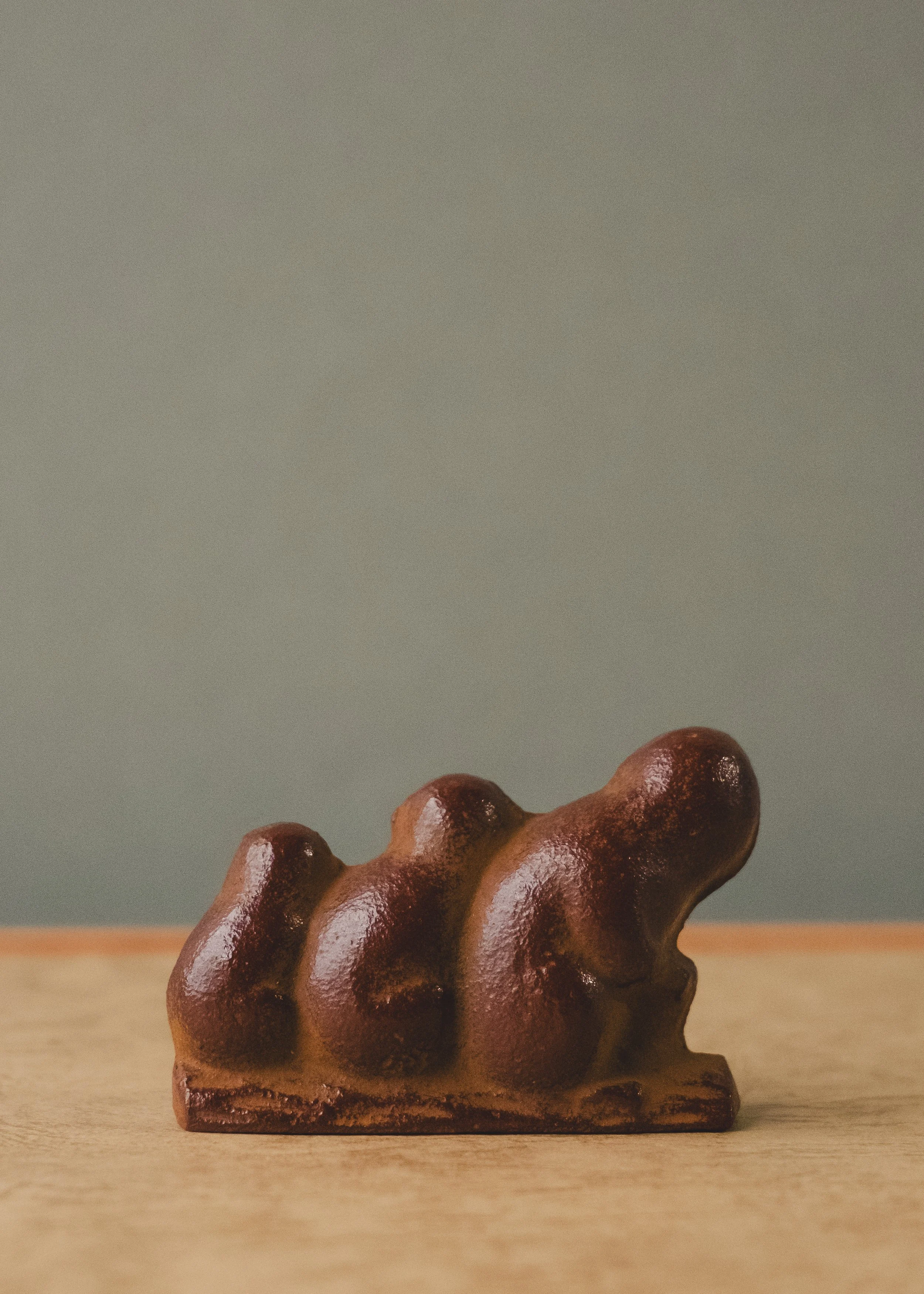 Minimalist Japanese iron monkey talisman. 1954 vintage cast-iron sculpture reflecting the bond of protection and the Mingei philosophy of functional art.
