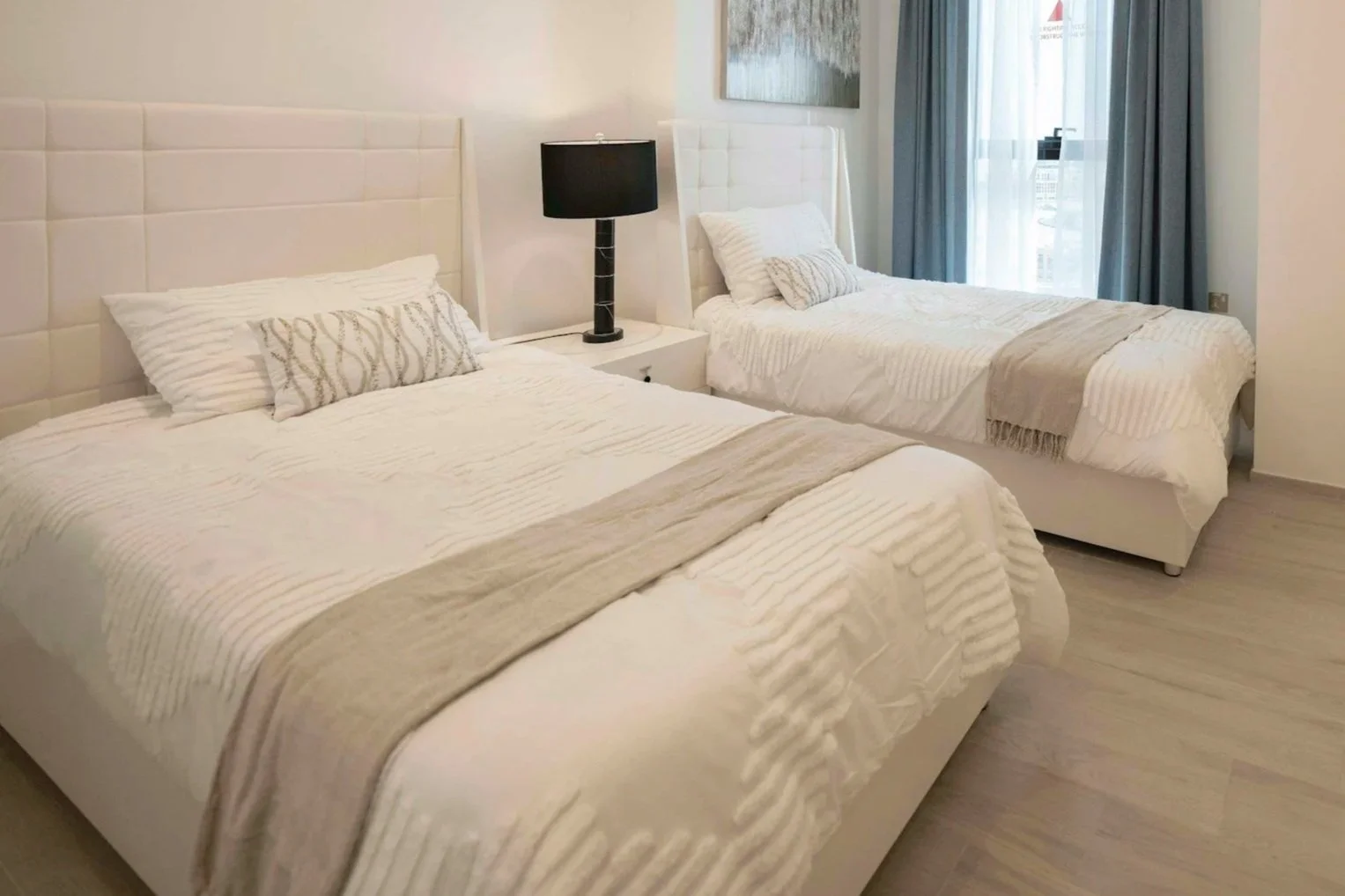 White Twin Beds with beige throw across bottom of bed