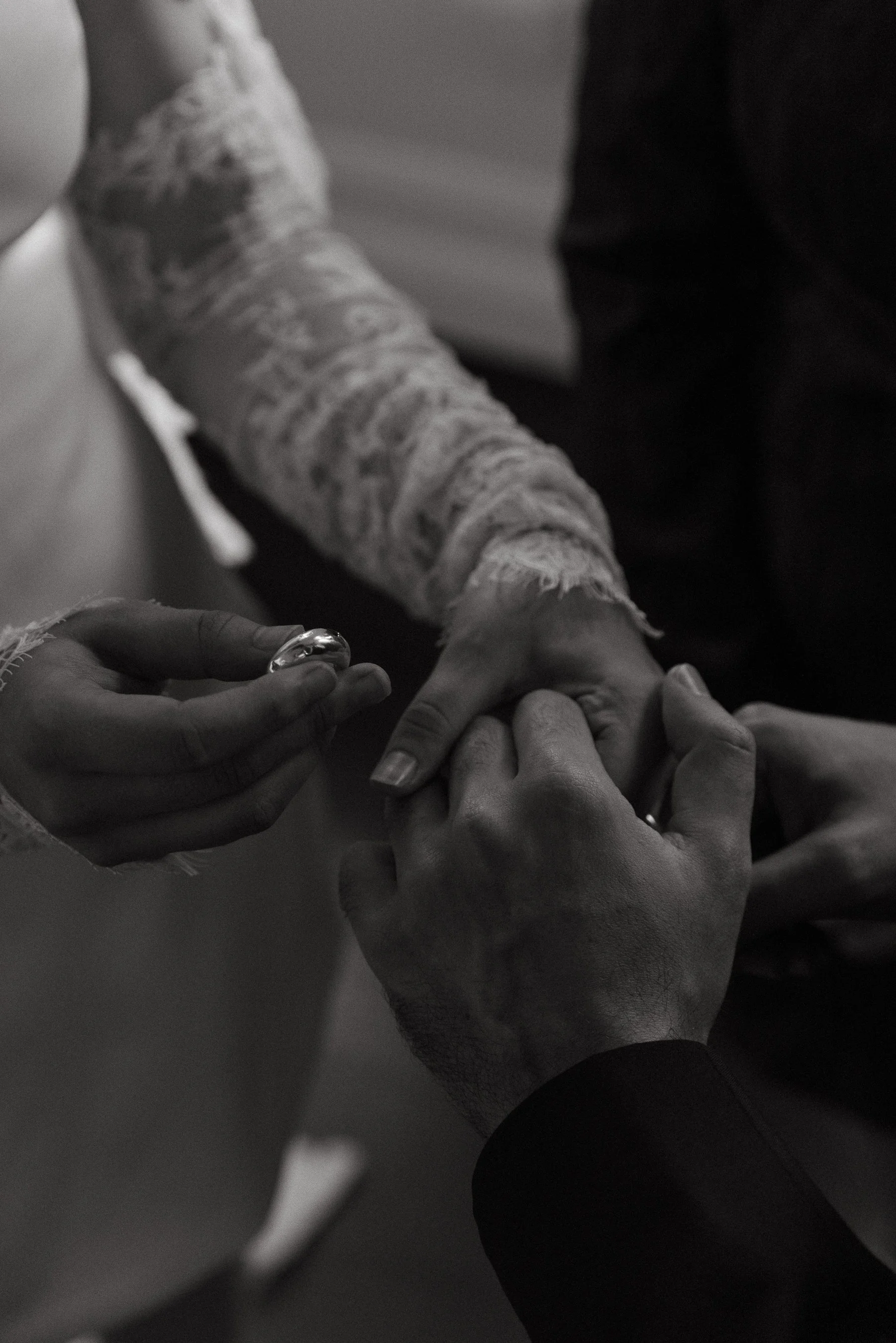 A person with a bandaged arm receives a ring from another person.